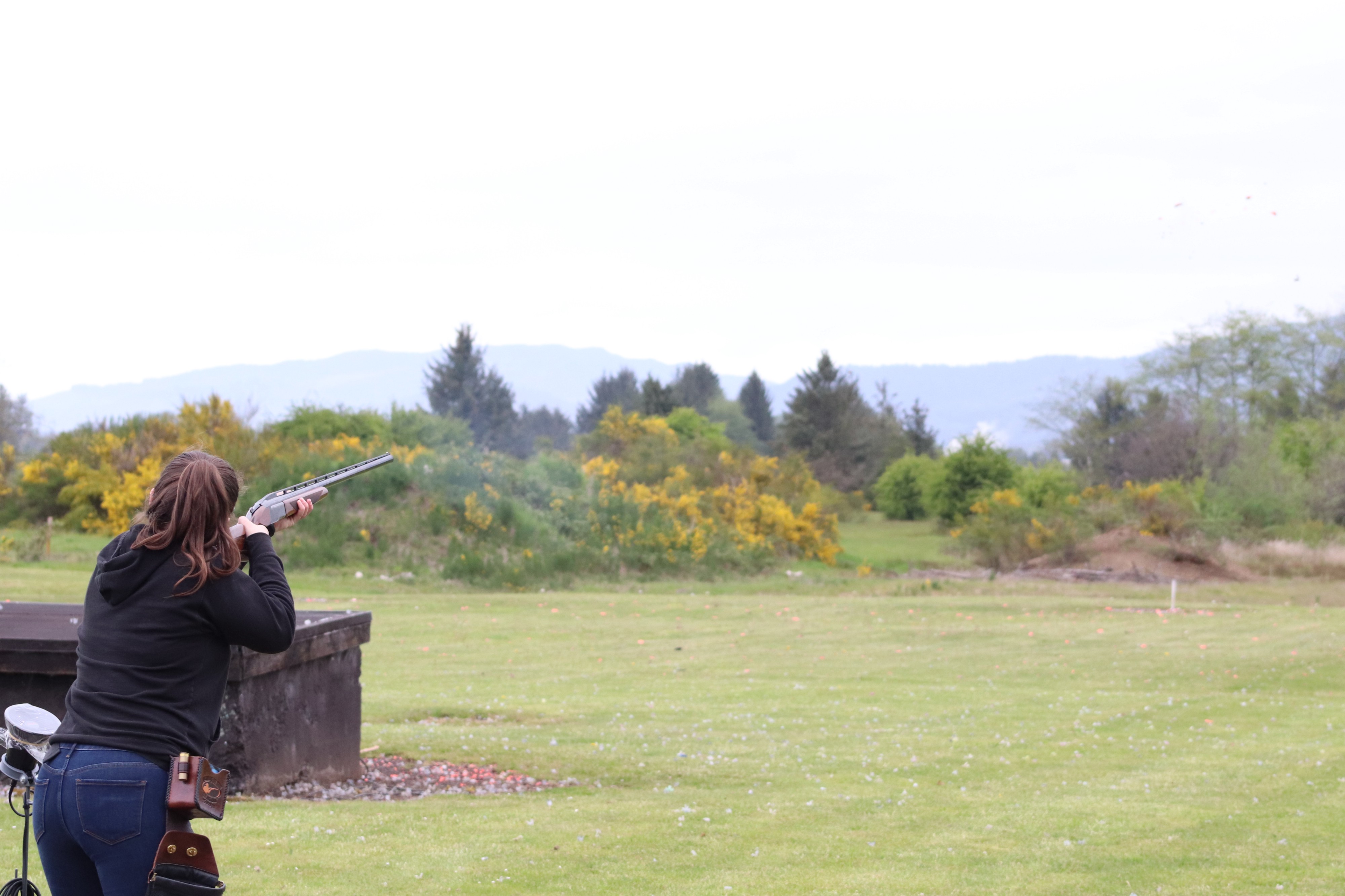 Charlotte Phillips shoots and collects her empty shells in a bag on her hip for later reloading.