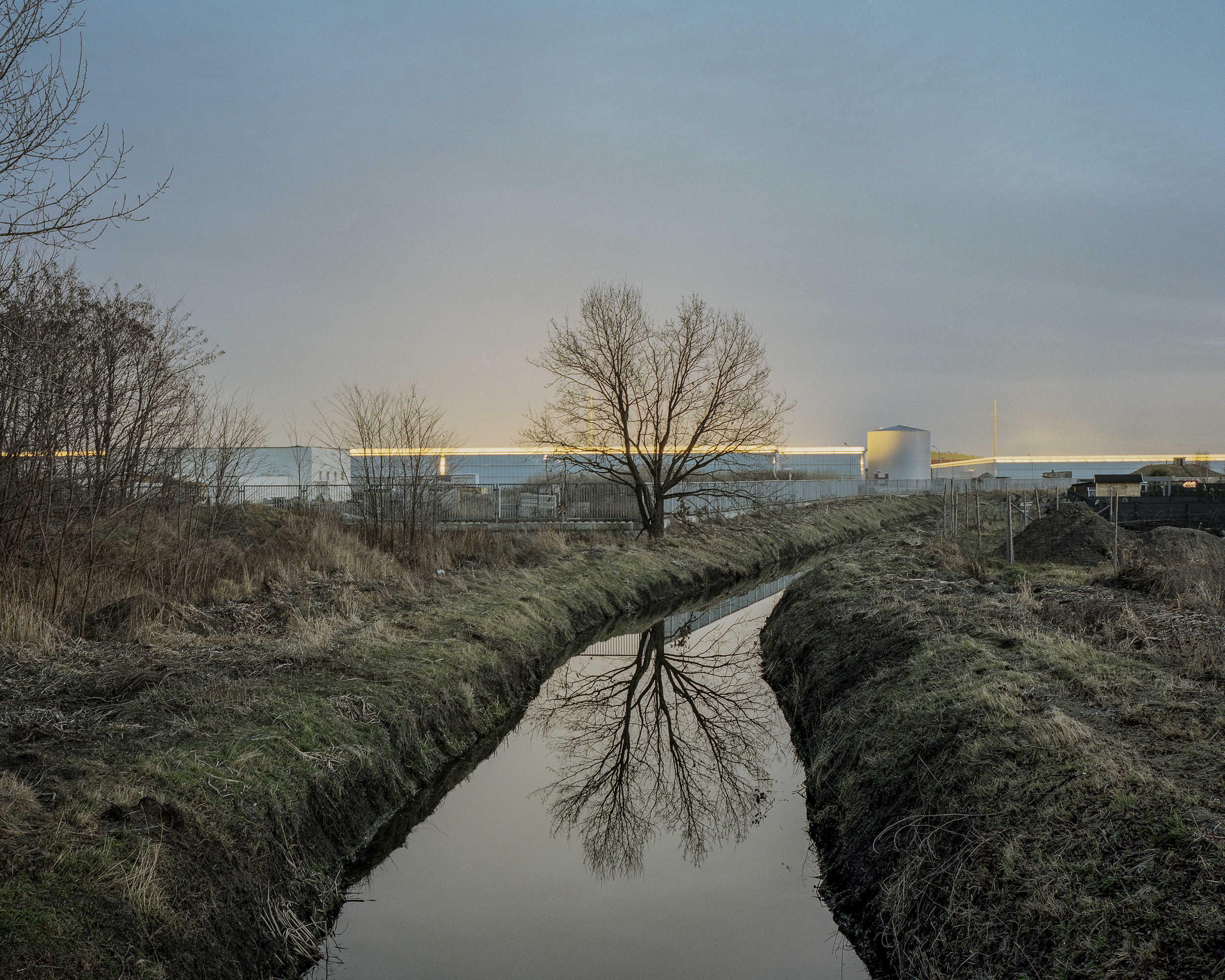 Over the last century, Siechnice turned from a suburban village into an independent town. Until the 1980s, there was an ironworks there, which was closed due to environmental concerns. The second area of production is food industry. Currently, tomato greenhouses in Siechnice are one of the largest in Europe. Urban sprawl of Wrocław means further population of the area with new housing estates. Combined with the expansion of agriculture production, it resulted in a conflict over the light pollution of the natural environment. As a temporary measure, greenhouses are partially covered at night, but at dusk the glow emanating from them is visible from several kilometers.
