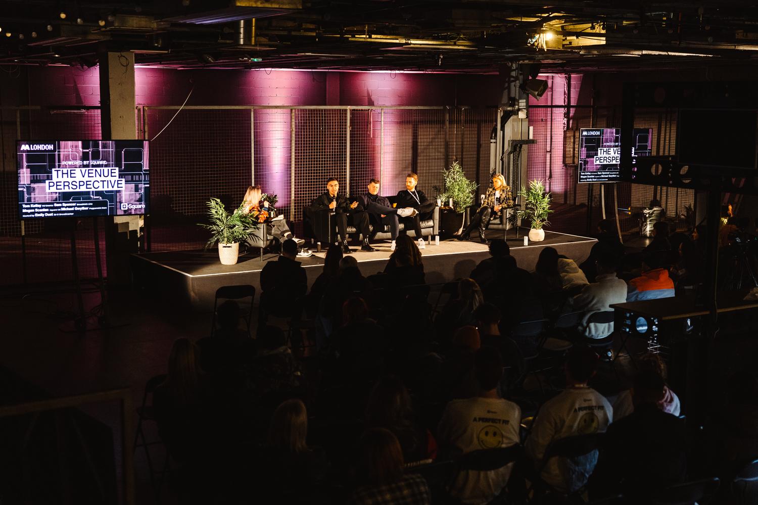 Panel discussion titled 'The Venue Perspective' on stage at AVA London with audience in attendance.