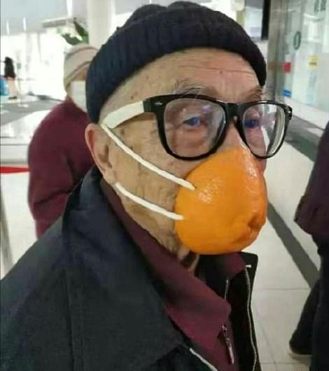 man with orange peel as face mask