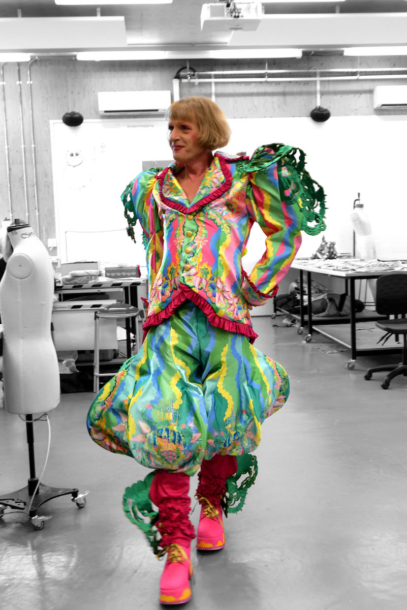 British artist, television presenter, and Turner Prize-winner Grayson Perry CBE RA in custom deadstock satin digitally printed suit trimmed with laser cut lace and ruffle detailing, featuring handpainted watercolour prints.