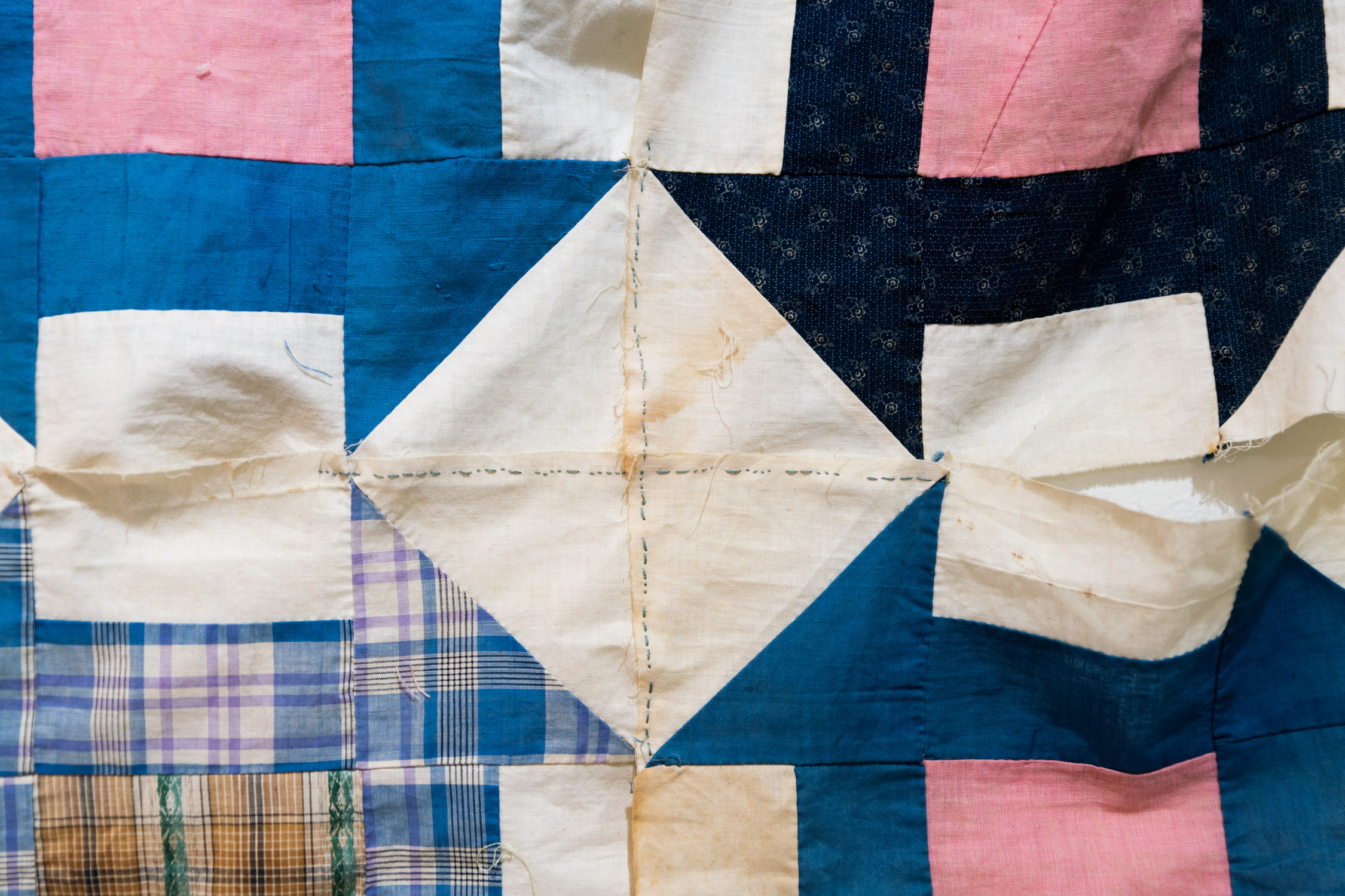 'Hand-Basted Crib Quilt.' Kris Blackmore, 2022. Abortion clinic geolocation data embroidered on antique quilt blocks. 45 x 54 in.
