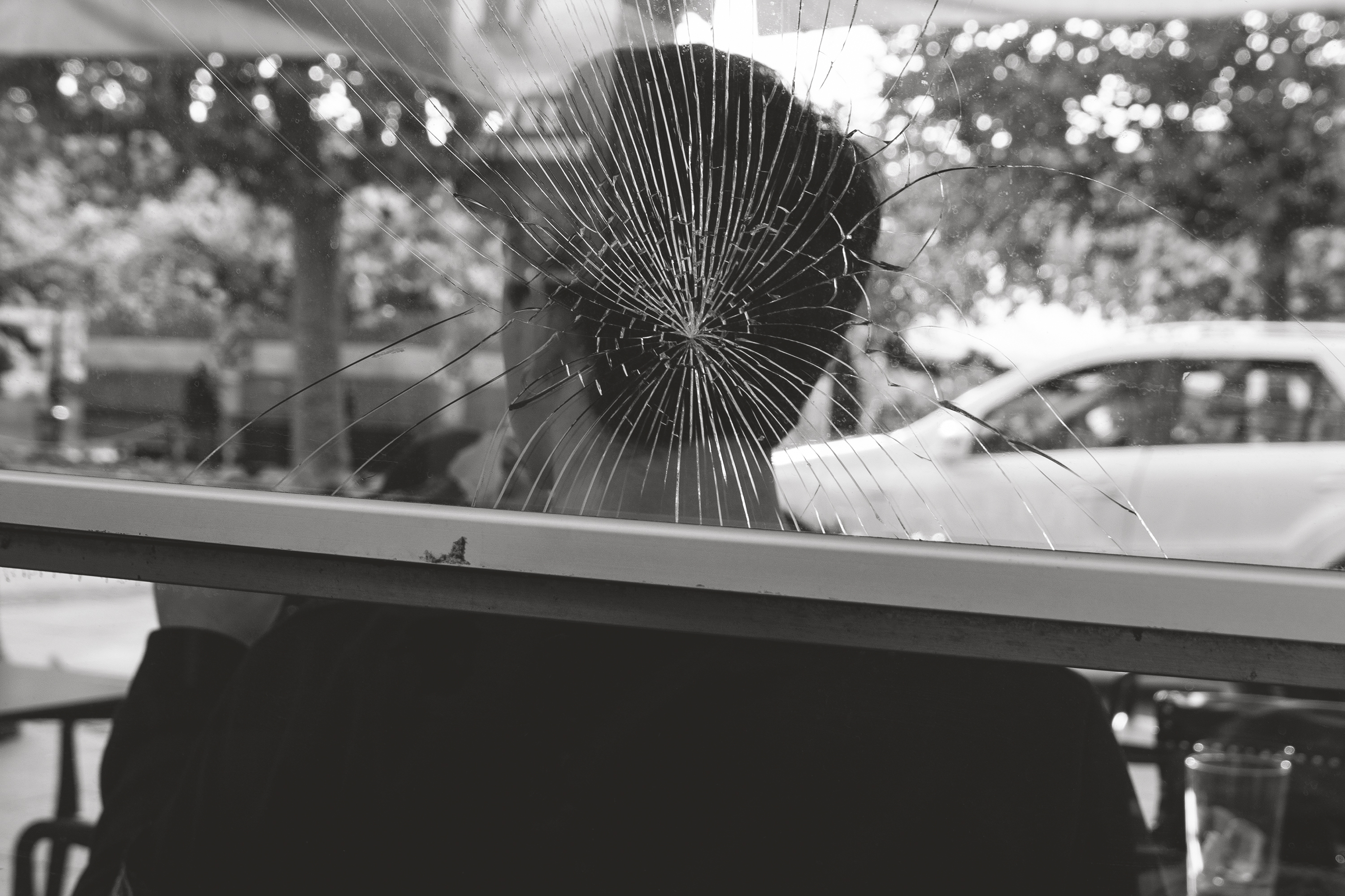 Young man behind broken glassPamplona, Spain, 2025photography, bw, single