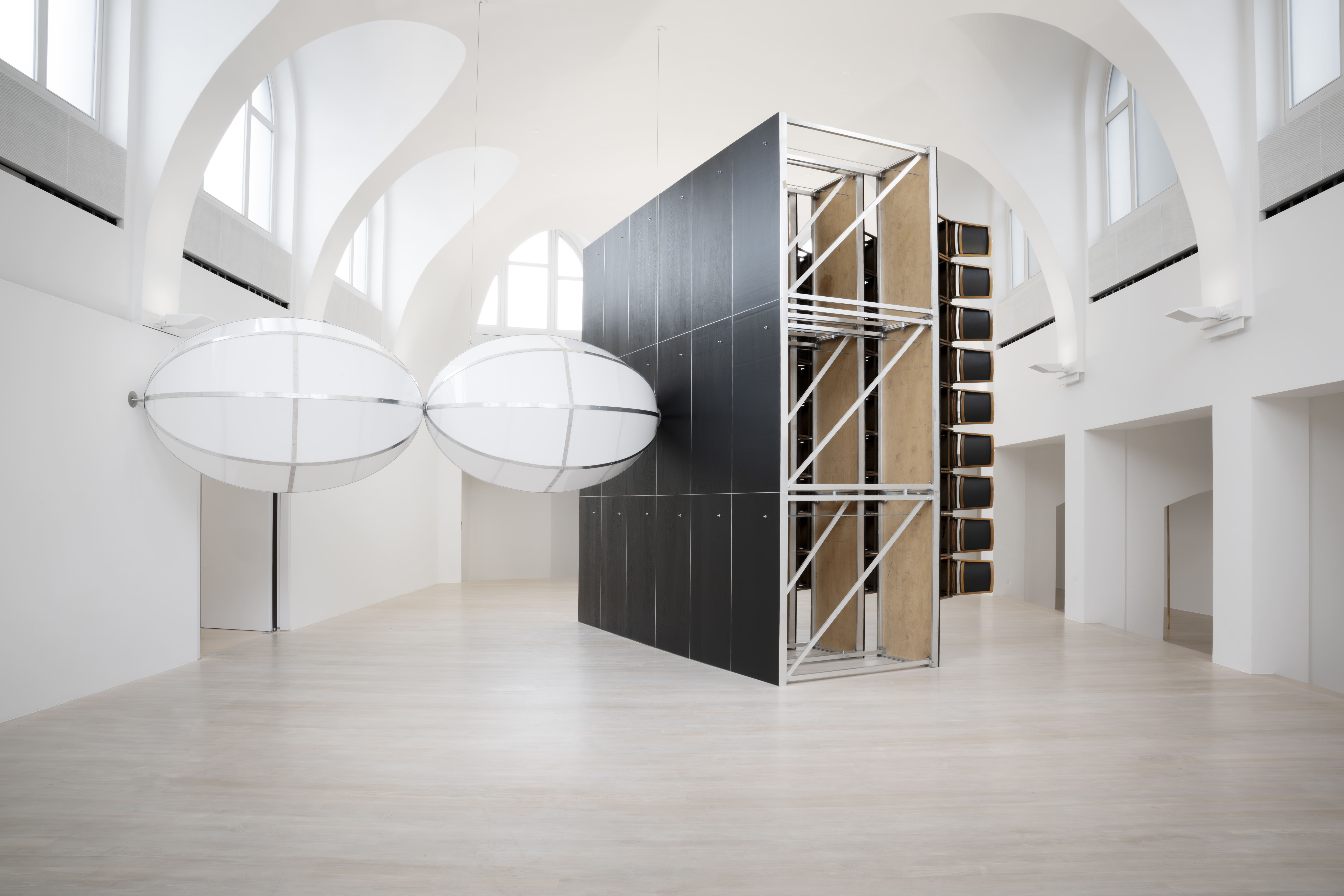 Cue the Cue, 2025, former theatre stand made of 64 antique chairs, silver-colored coins, plexiglass, aluminum, dimensions variable