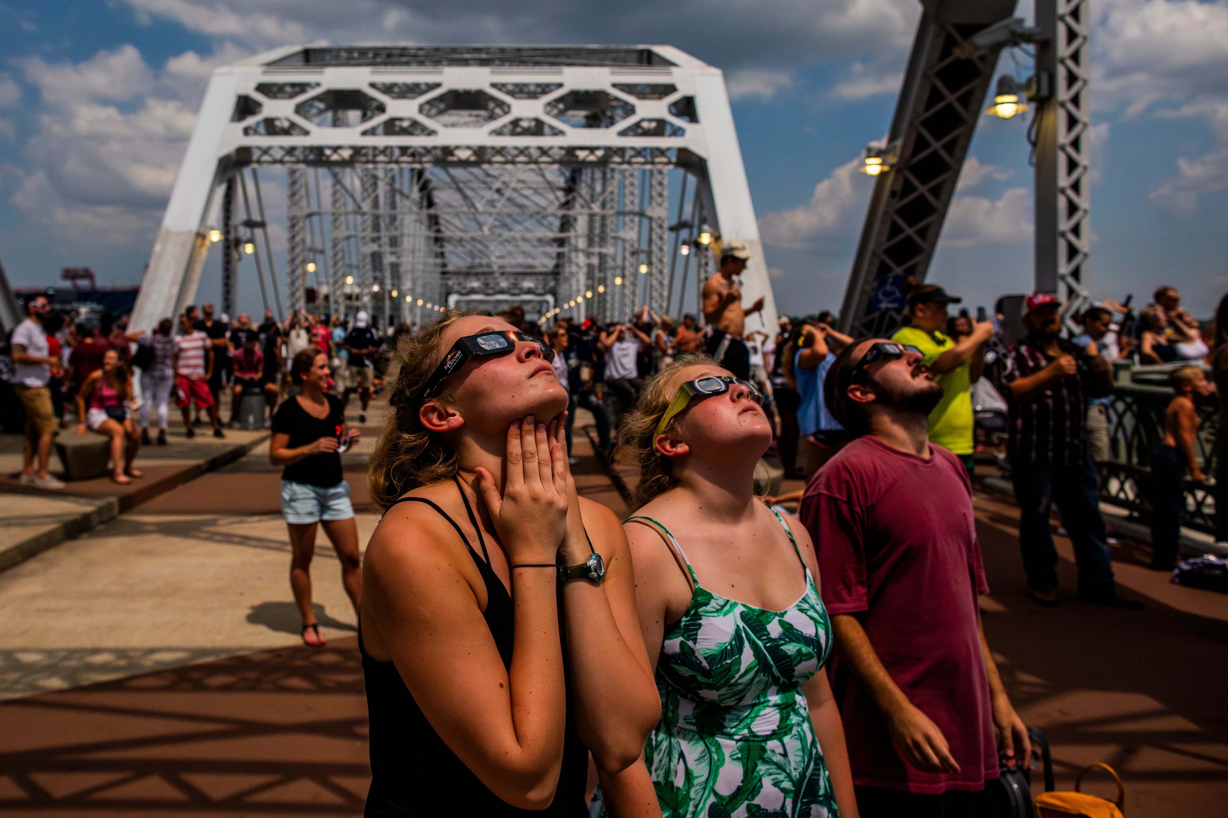 People pack onto the John Seigenthaler Pedestrian Bridge to watch a total solar eclipse in Nashville, Tenn. (The New York Times)