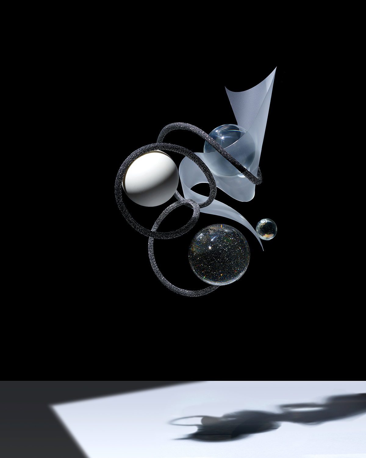 KMA photographer Isabelle Bonjean shoots grey black and white glittery objects floating