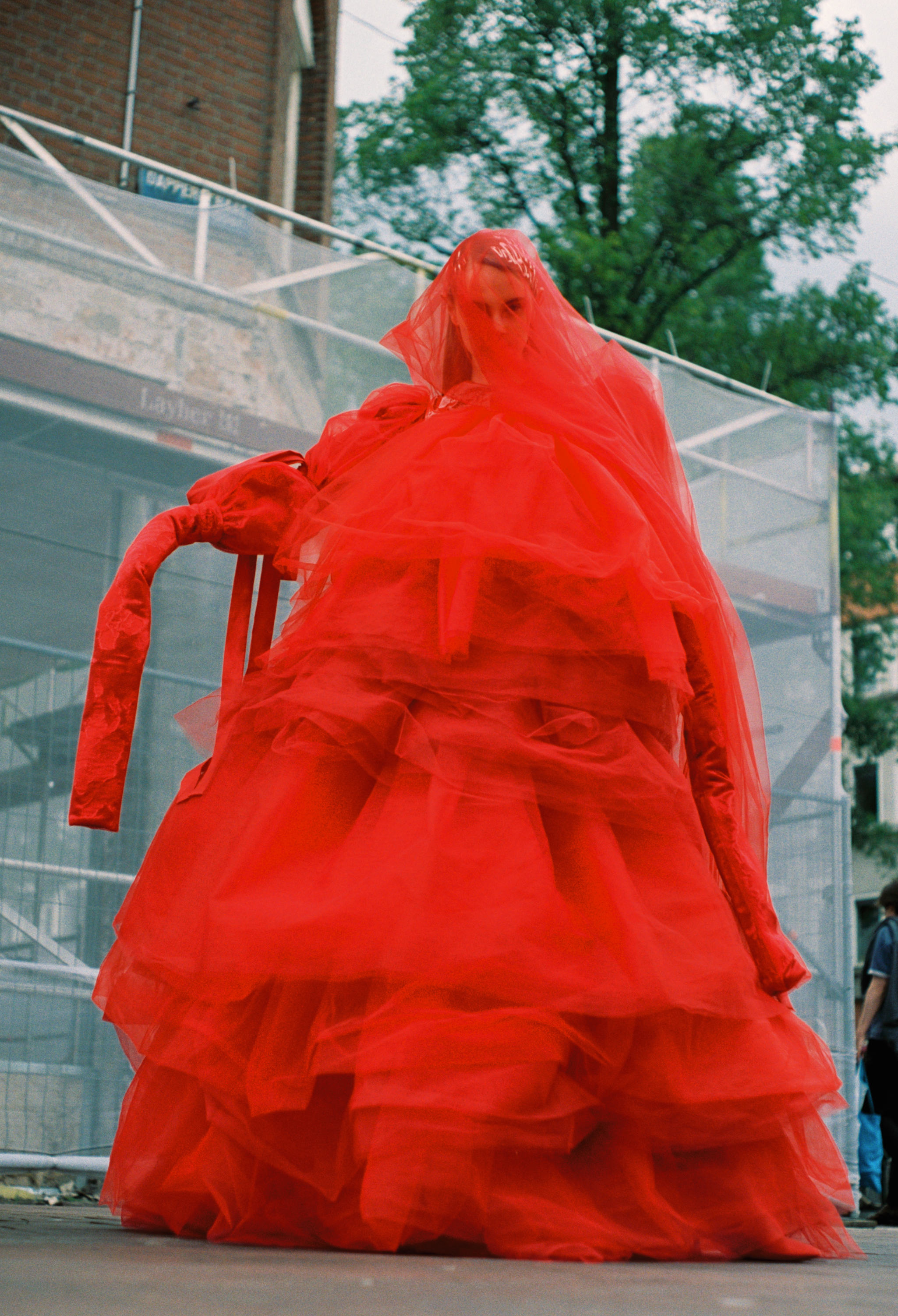 Fashion model in big red dress on sidewalk