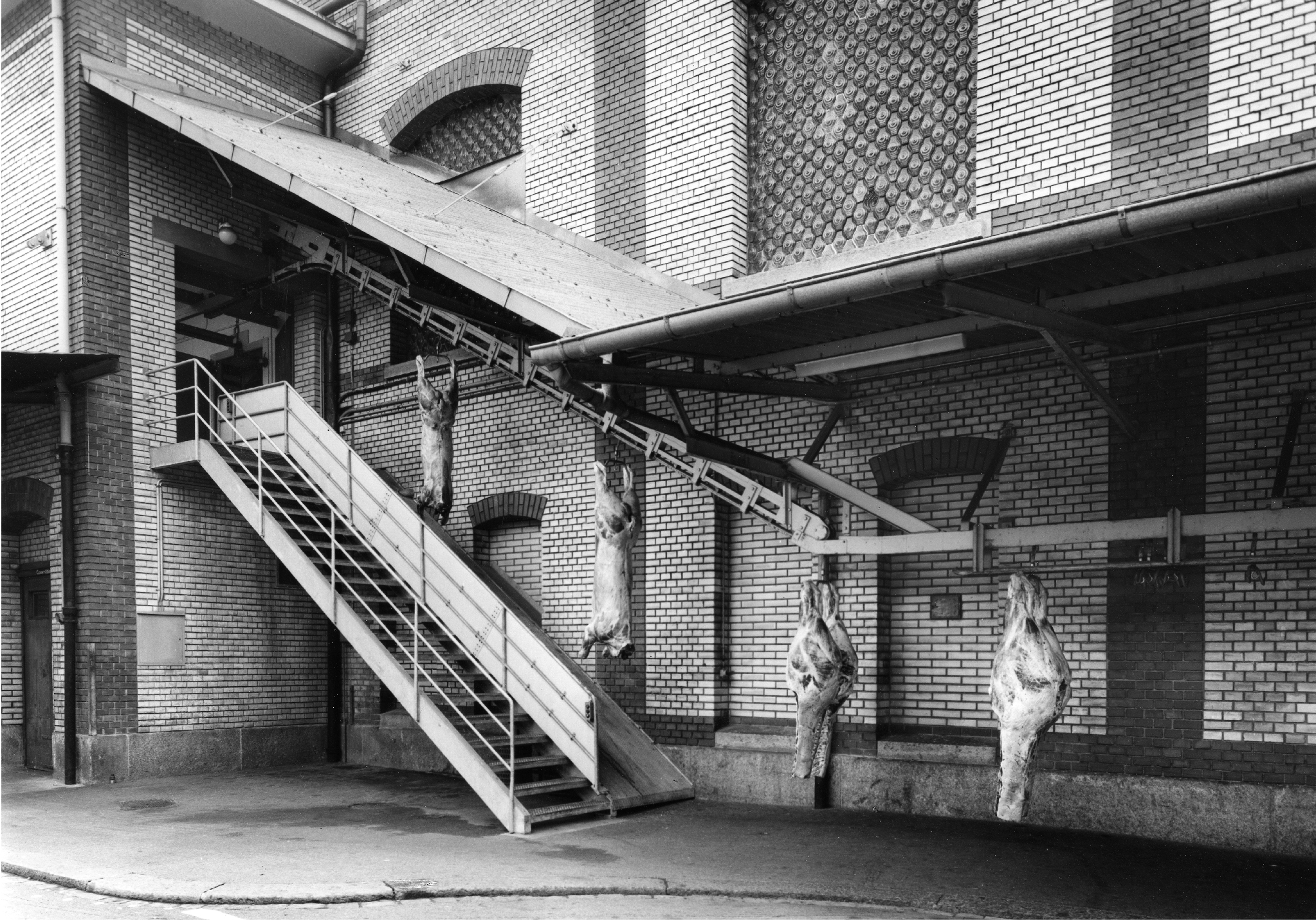 Slaugher bodies carried over stairs to the exterior by the transport rail, Schlachthof Zürich, 1960, Erwin Kuenzi. Source: Baugeschichtliches Archiv der Stadt Zürich