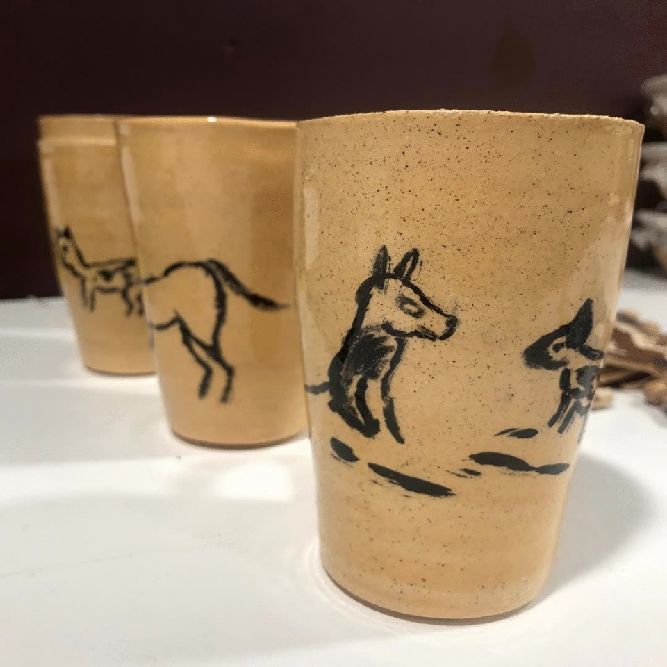 Three ceramic handless mugs. Sand coloured with animal illustration painted on by Peter Hodgson.