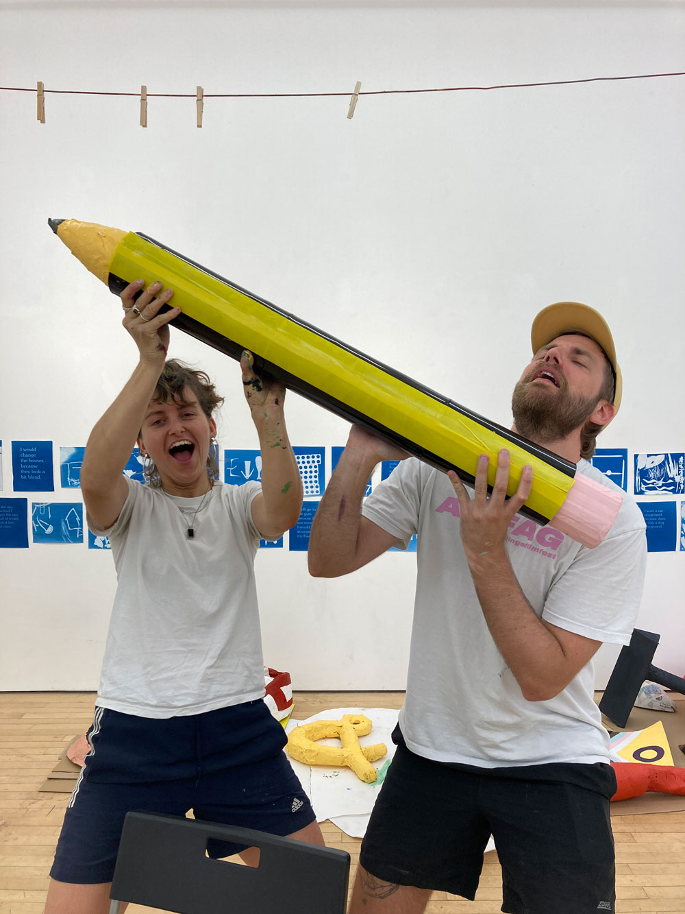 Ros Wilson and Fredde Lanka from Queer Youth Arts Collective making giant pencil!