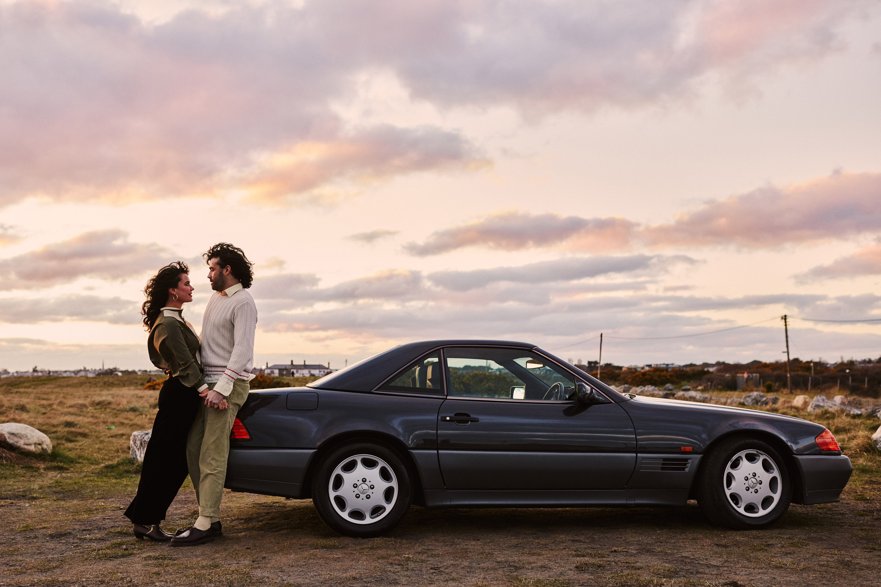 A story of young love in the suburbs told through photography, featuring stylish models in vintage clothing, photographed at sunset in Dublin, Ireland by fashion and lifestyle photographer Alex Sheridan. Suburban Love photo series. Featuring a vintage 1993 Mercedes Benz SL class and cinematic lighting and red light. Euphoria inspired photoshoot.