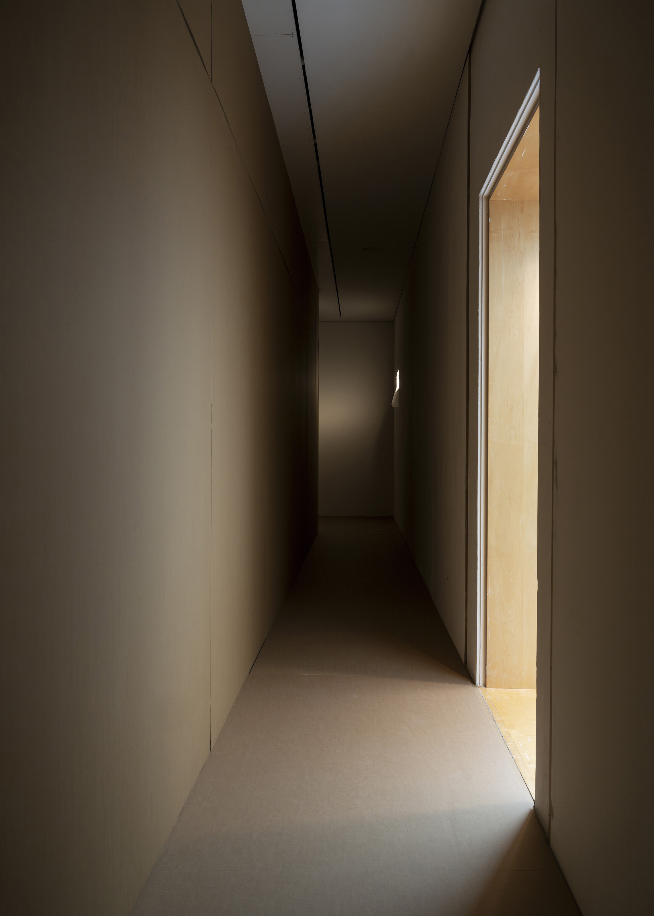 Thereafter, 2025. Environment consisting of cardboard walls and floor, wall cutouts with plastic film, sound, light intervention, alteration of the main entrance. Site-specific dimensions.