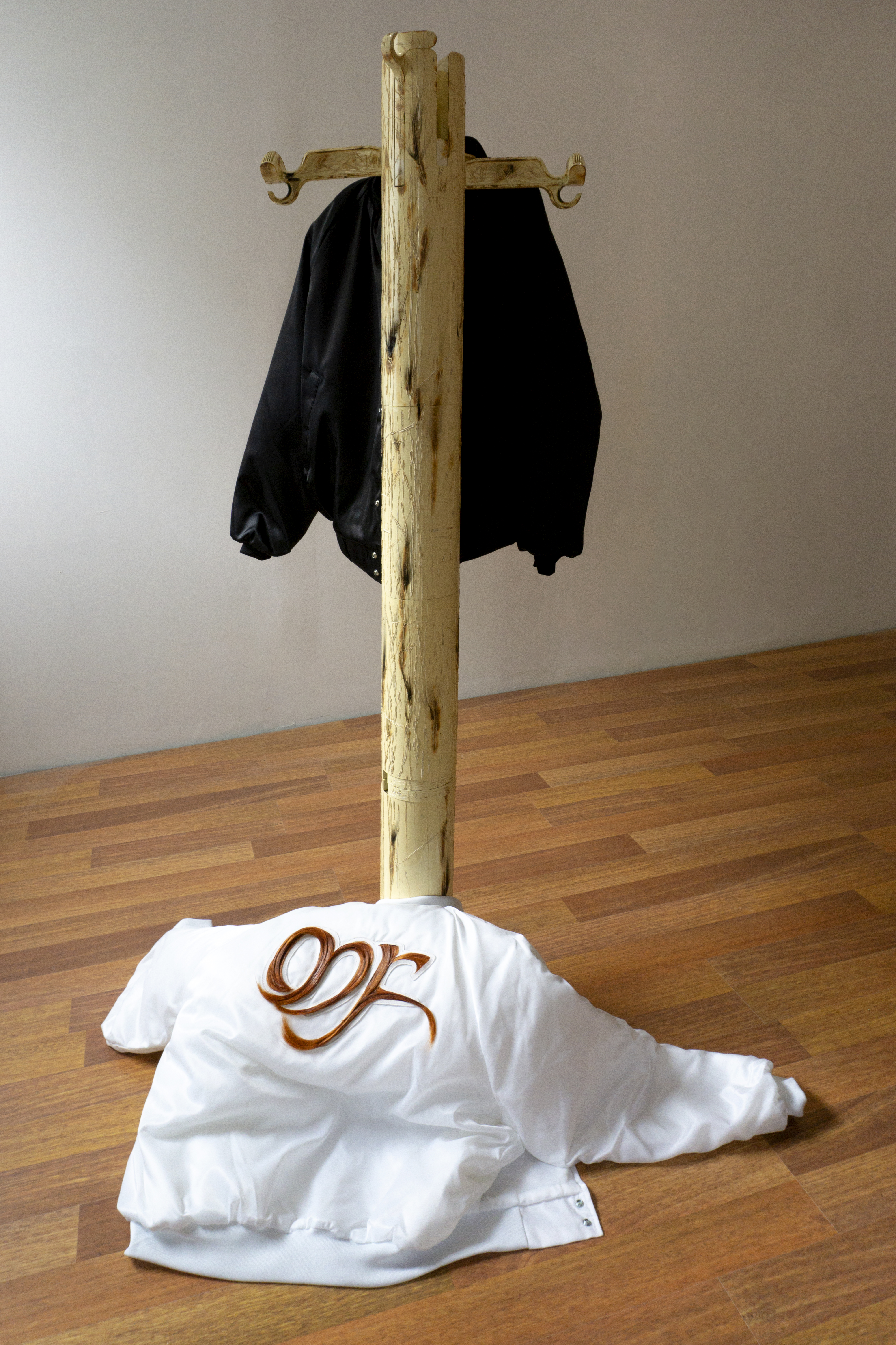 Cécile di Giovanni, M.F., 2020. Installation. Red hair, leather, white and black satin jacket, plastic coat rack. Variable sizes.