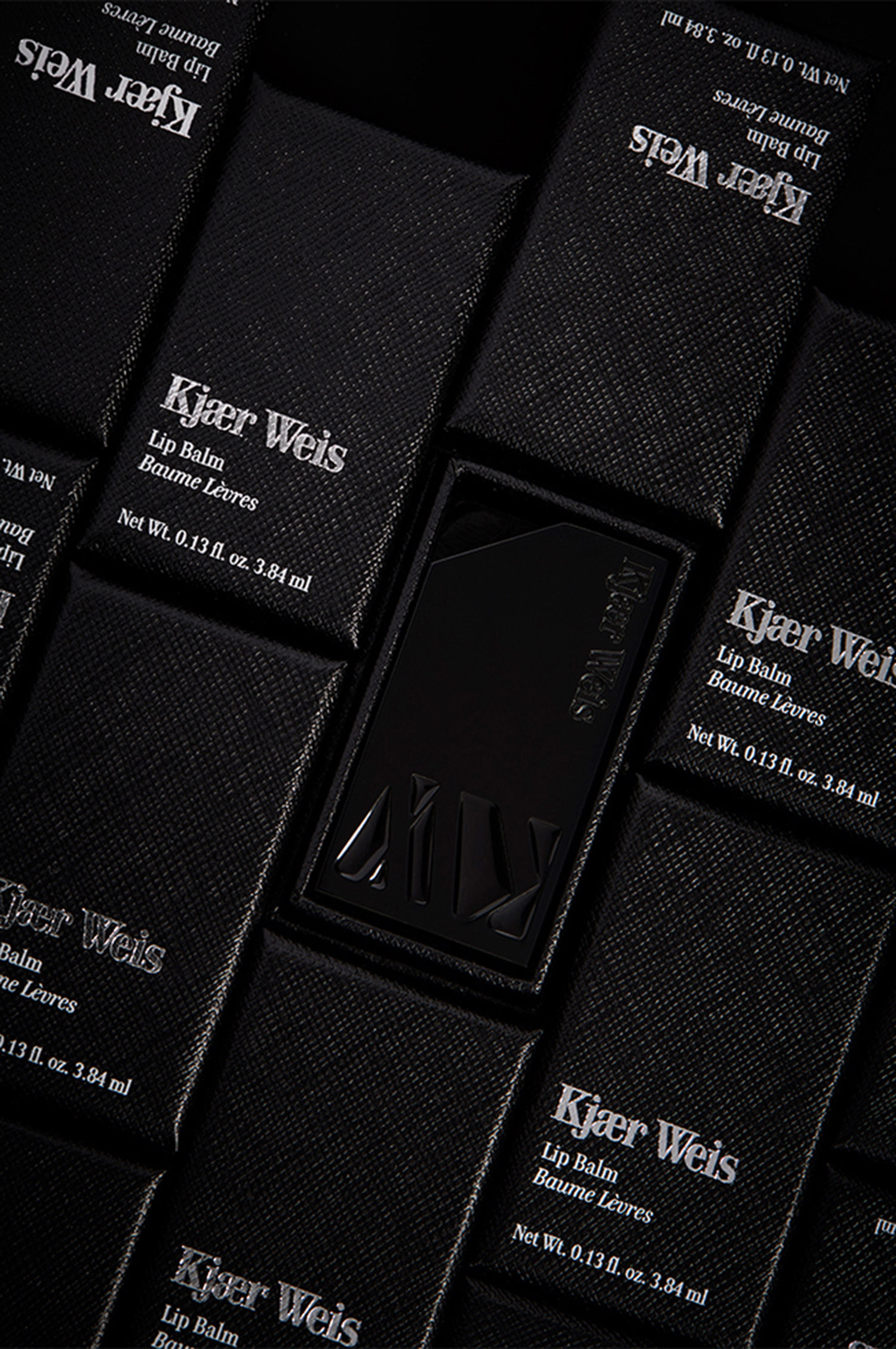 KMA stylist Sara Wacksman designs set for photo of Kjaer Weis lip balm bottles laying on side arranged in vertical lines