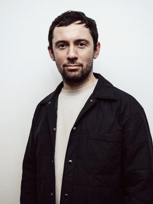 Joe Baran, Event Director at UP! Productions, wearing a dark jacket and standing against a light background.