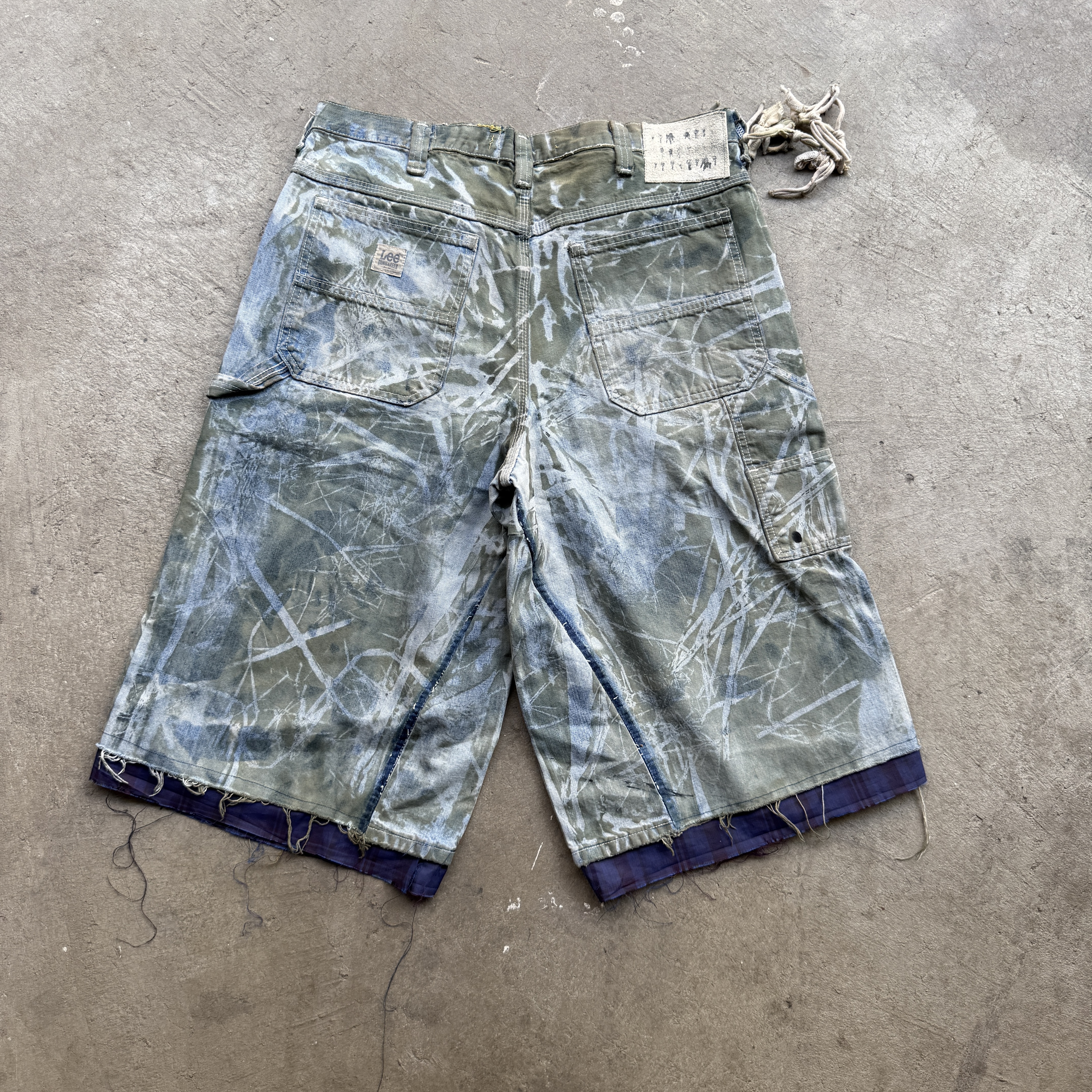 Reclaimed vintage surplus denim screen printed with grass pigment & textile dye. Tailored to give straight/wide fit. Fitted with dyed scrap chain, leather back patch, and custom buttons.