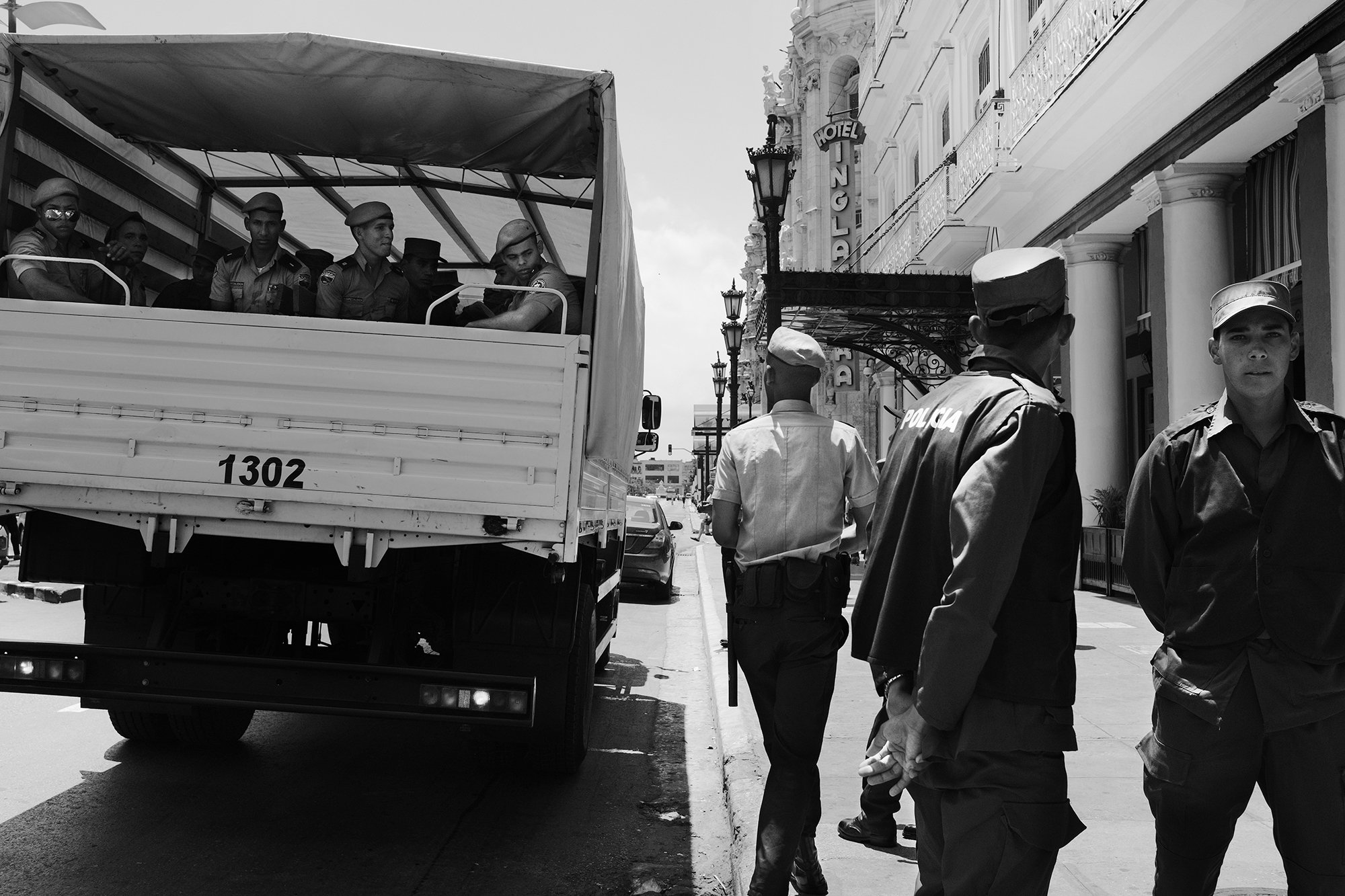 Philippe-Sarfati-soft-revolution-photography-photographer-street-documentary-cuba-castro-era-change-black-and-white-havana-hotel-inglaterra-kids-young-military-men-waiting-truck-discussion-joke