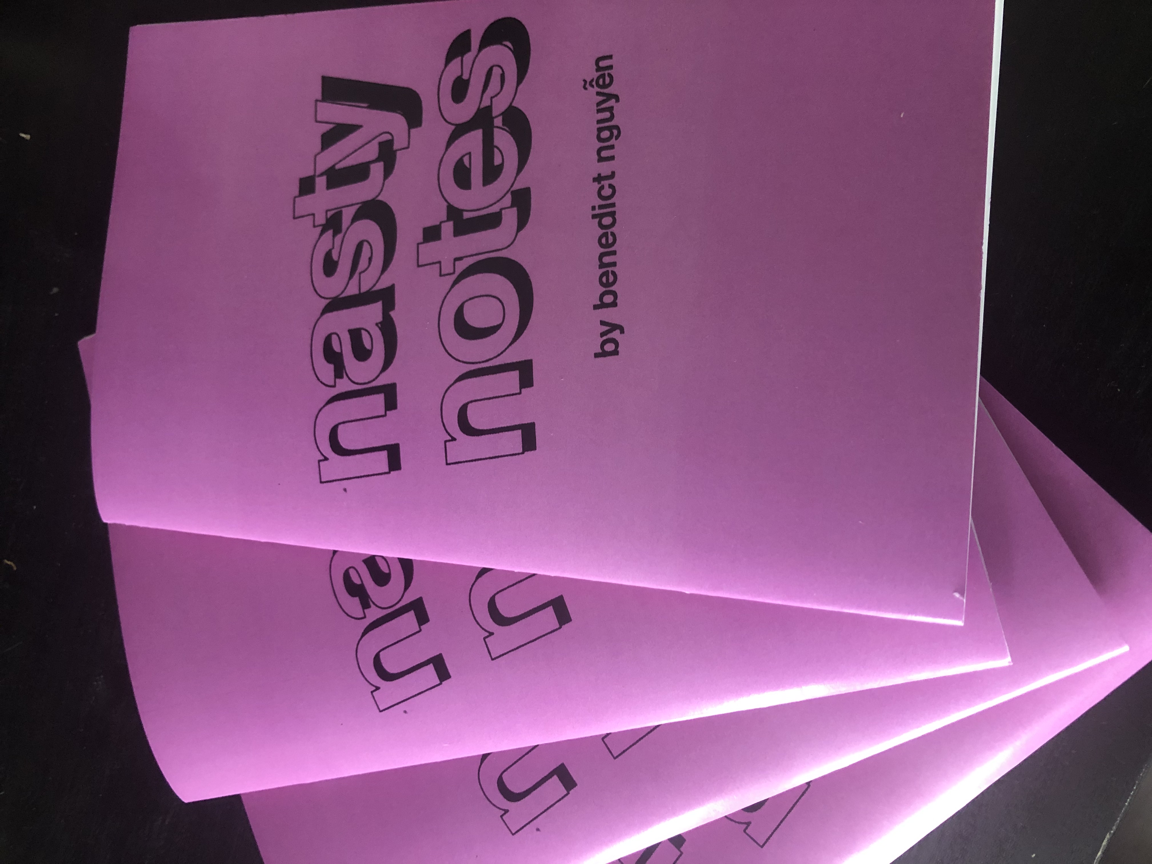 copies of "nasty notes" arranged in a fan: pink-purplish cover with "nasty notes" in black block lettering and "by benedict nguyễn" in bold black ink