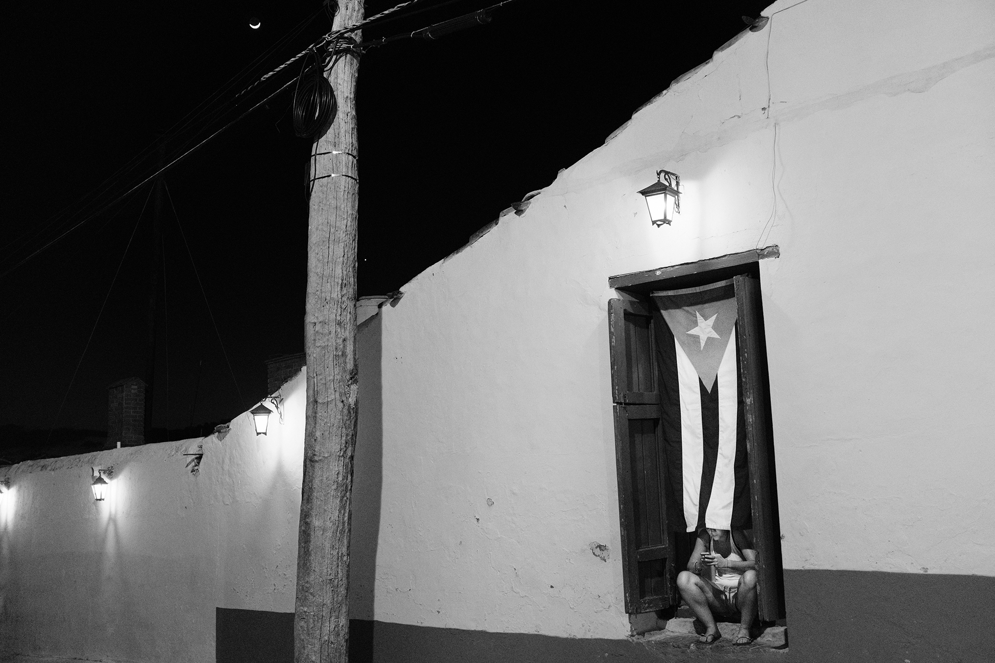 Philippe-Sarfati-soft-revolution-photography-photographer-street-documentary-cuba-castro-era-change-street-trinidad-night-moon-smartphone-flag-lights-black-and-white