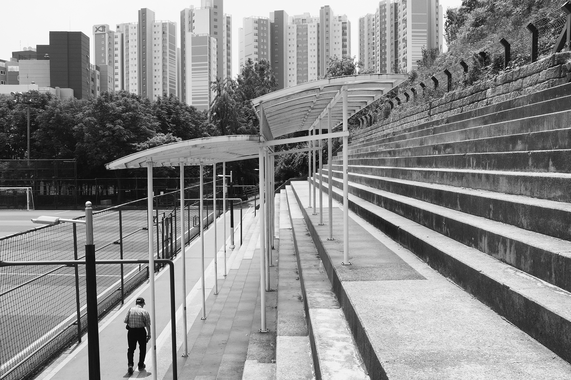 Philippe-Sarfati-early-work-photography-photographer-street-documentary-black-and-white-seoul-south-korea-lines-abstract-towers-geometry-city-skyline-man-walking-heat-empty-space