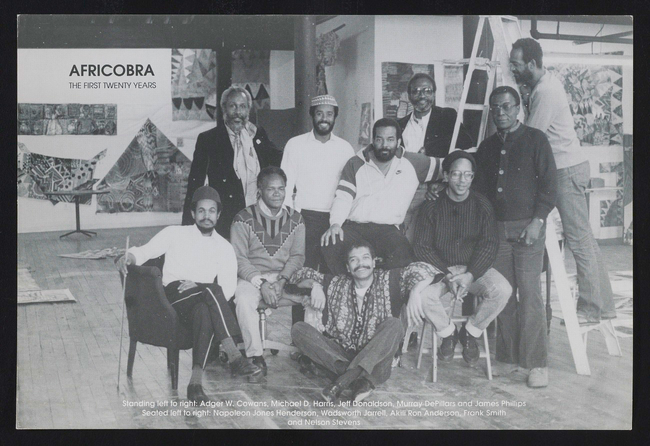 Image: A black-and-white Postcard [front] for AFRICOBRA: the First Twenty Years at Nexus Contemporary Art Center, Atlanta, GA, 1990. Image shows ten AFRICOBRA members sit in an art studio or gallery. Standing left to right: Adger W. Cowans, Michael D. Harris, Jeff Donaldson, Murray DePillars, and James Phillips. Seated left to right: Napoleon Jones Henderson, Wadsworth Jarrell, Akili Ron Anderson, Frank Smith, and Nelson Stevens. Archives of American Art, Smithsonian Institution.