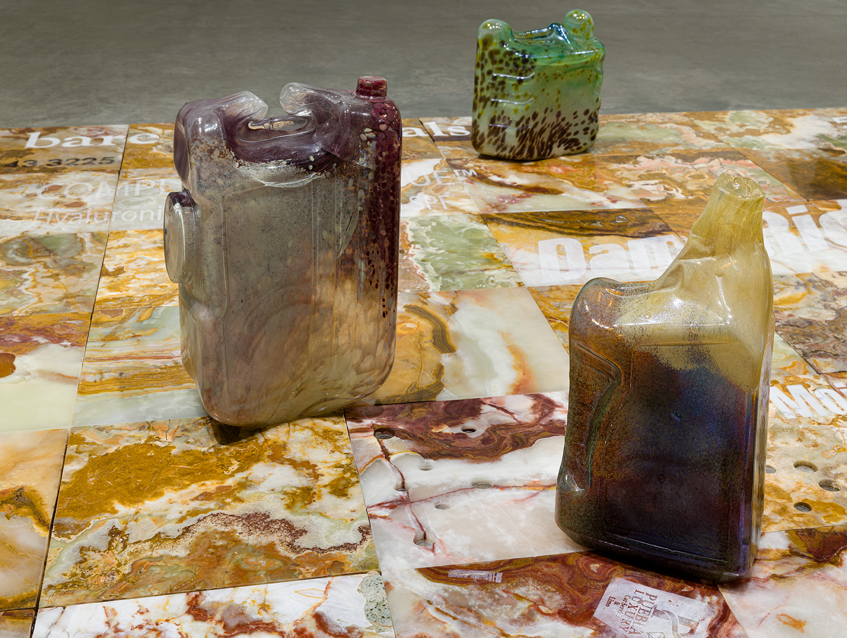 Details of Catherine Telford Keogh, "Compost Index 3 with Volume 2.1, 2.2, 3.1, 4.1, 4.2, 5.1," 2023. Sandblasted Salvaged Multicolor Onyx Tiles, Waterjet Salvaged Italian Marble Tiles, Mold Blown Glass CLEARA™ H2O Filter System Dispenser, Mold Blown Glass Super Tech Full Synthetic SAE™ 5W-30 Motor Oil, 5 Quarts, Mold Blown Glass Sun® Liquid Laundry Detergent, Clean & Fresh, Mold Blown Glass AquaNation™ 5 Gallon Water Bottle Jug, and Coins, 144 1/2 x 72 1/2  x 17 inches. Photo by Etienne Frossard.