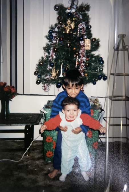 Sharon and her older brother pose in front of their Christmas tree (1999). Link to full story: tinyurl.com/GenSharon