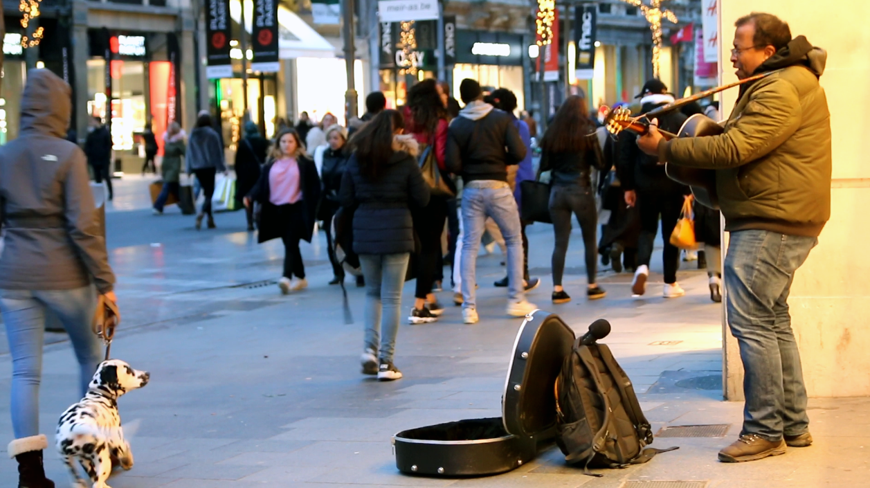 Michael Houston busks on a busy shopping street in Antwerp