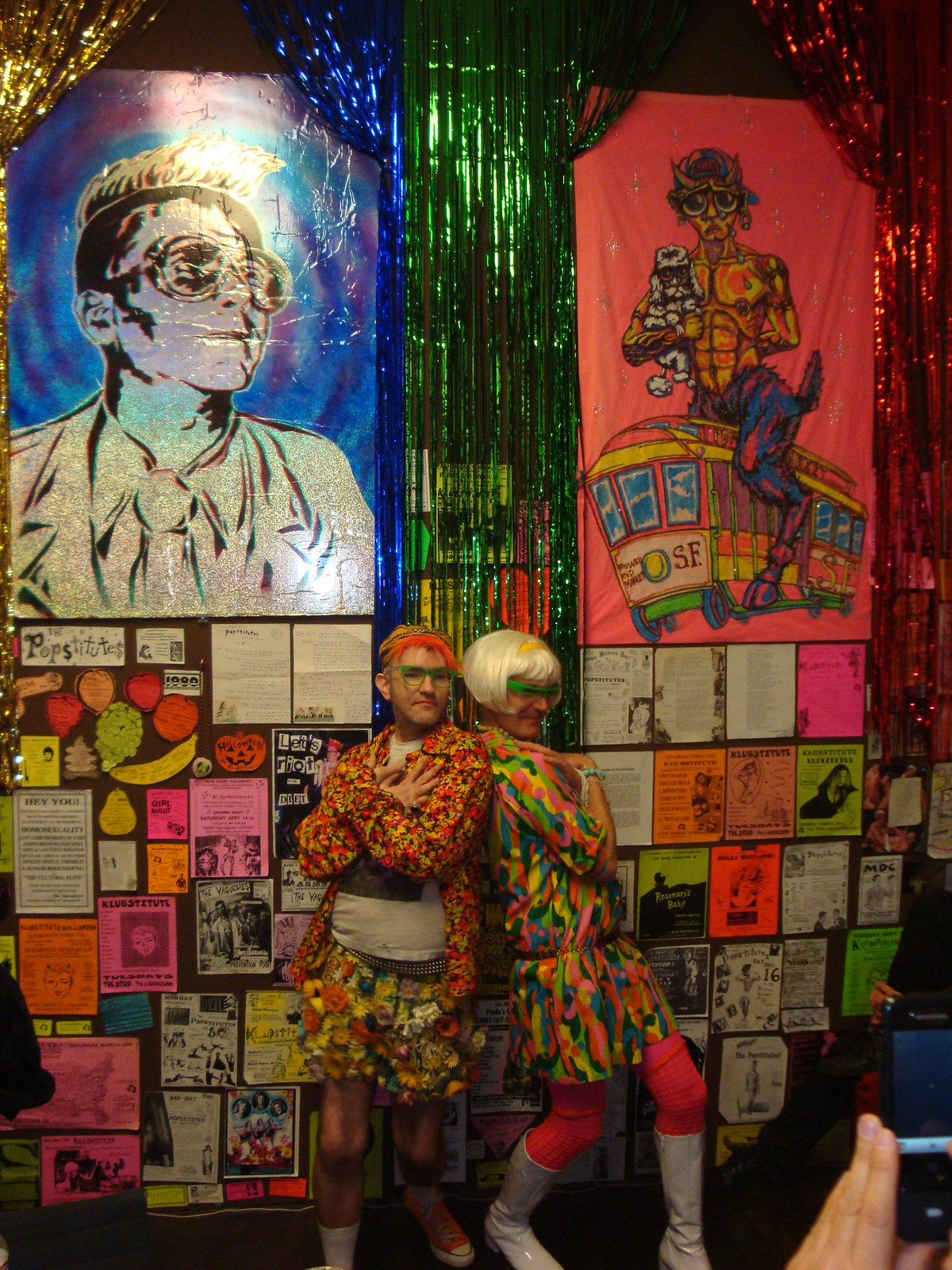 Tony Vaguely and Gary Fembot posing in front of artwork by Tyler Ingolia.