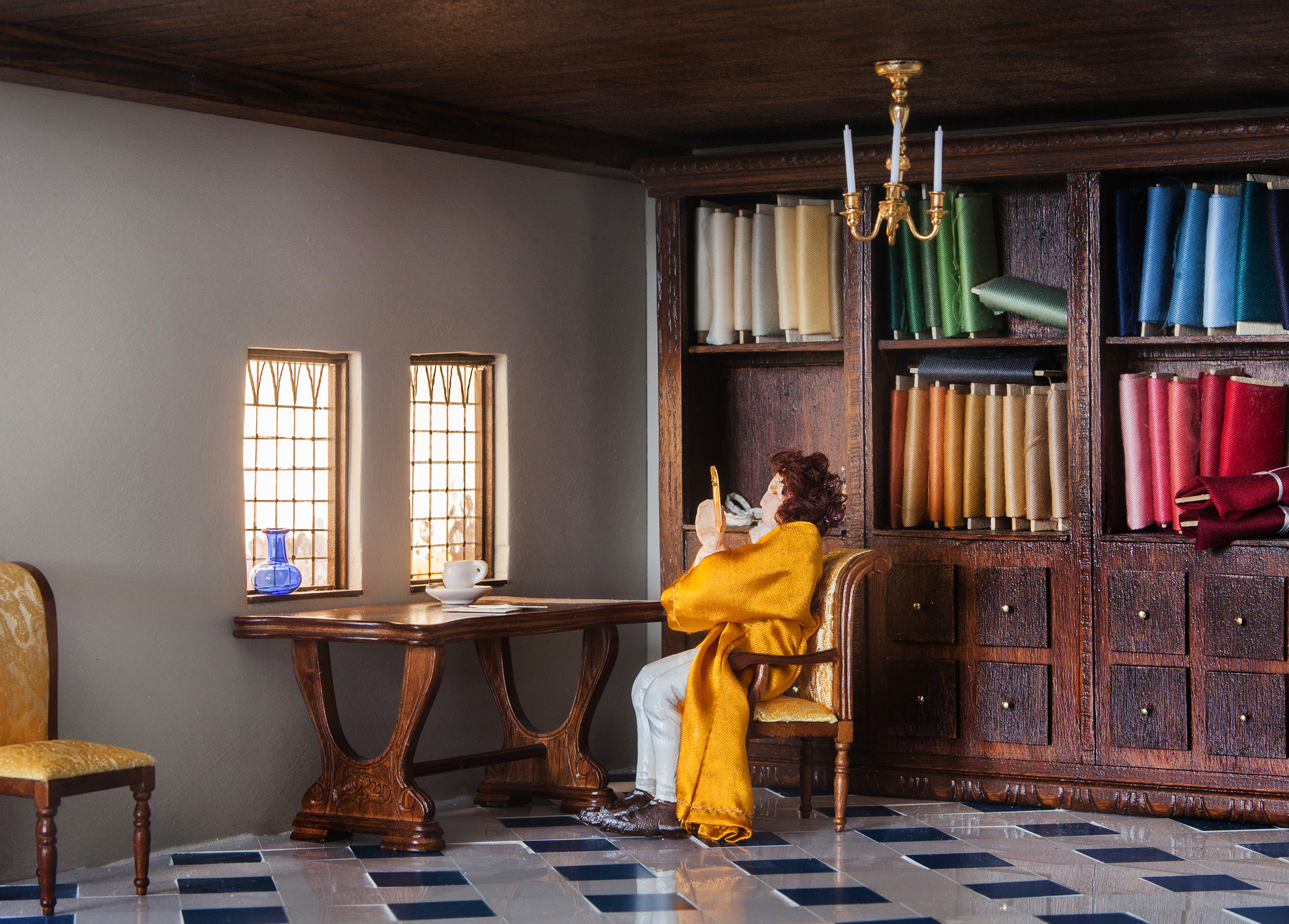 "Miniature diorama of Anton Van Leeuwenhoek’s fabric shop," Miniature Anton Van Leeuwenhoek, furniture, print of Vermeer's painting View of Delft through glass windows