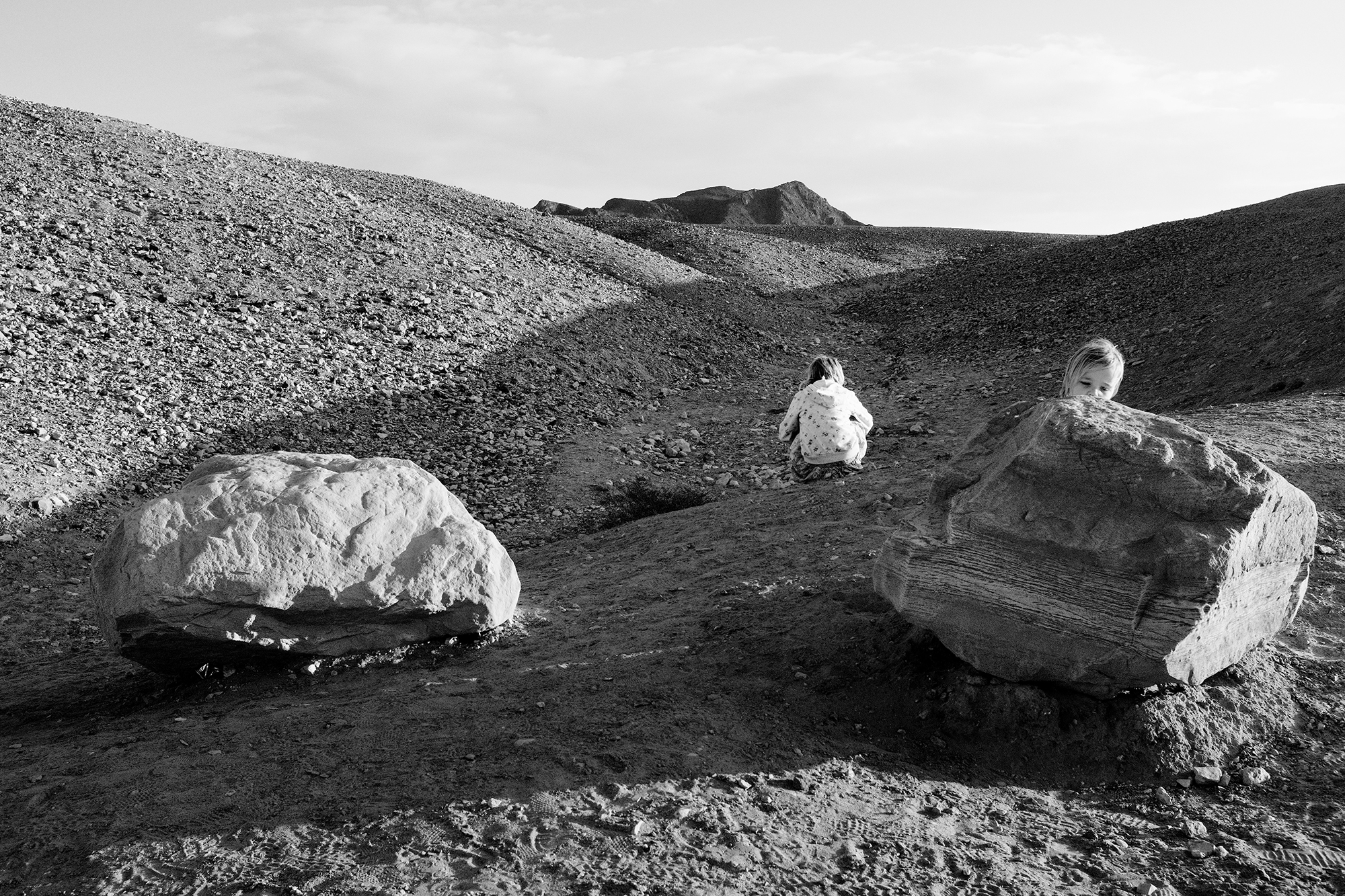 Philippe-Sarfati-early-work-photography-photographer-street-documentary-black-and-white-israel-negev-desert-hills-big-rocks-rough-texture-children-observing-playing-landscape