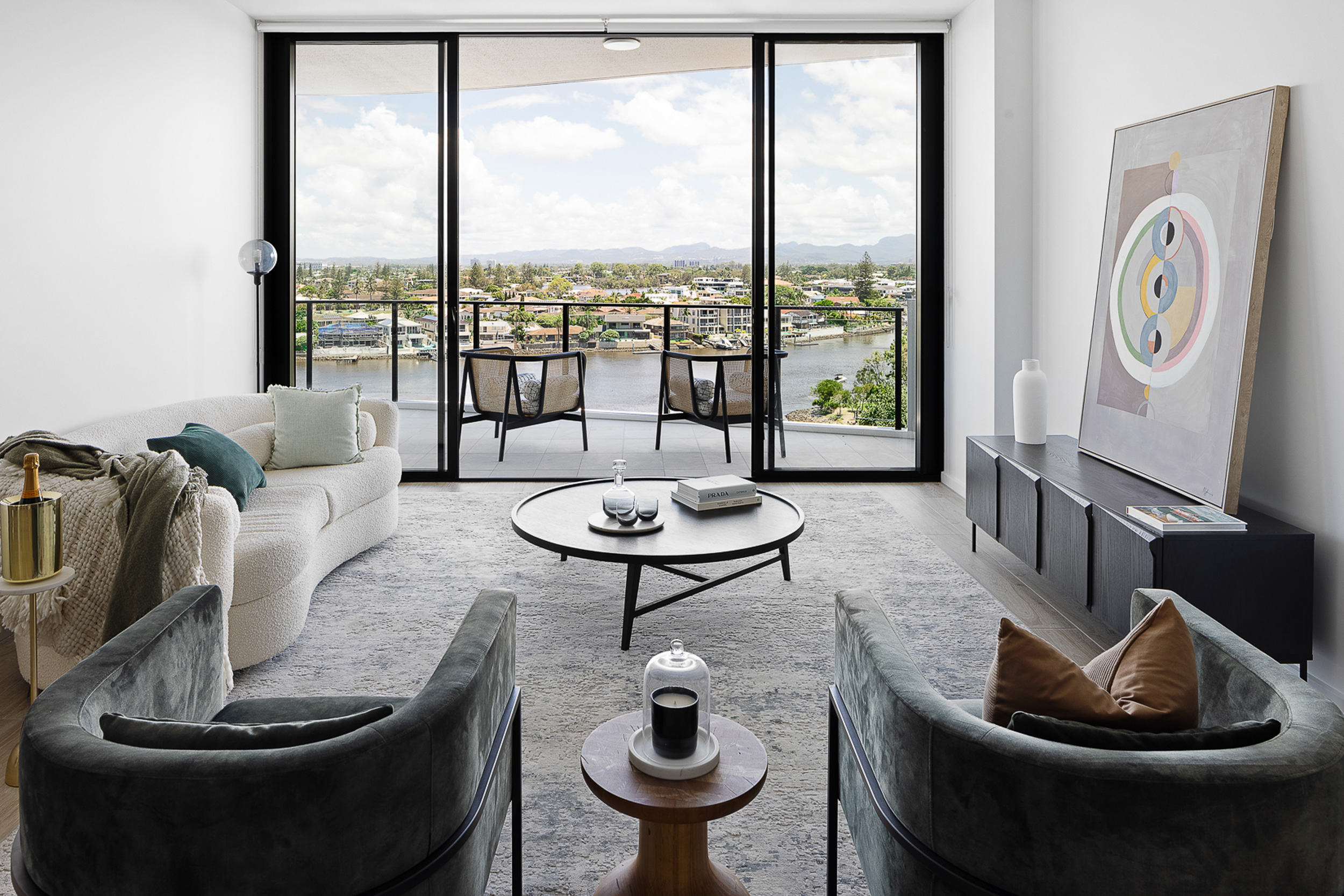 A contemporary living room with panoramic city view through large windows.