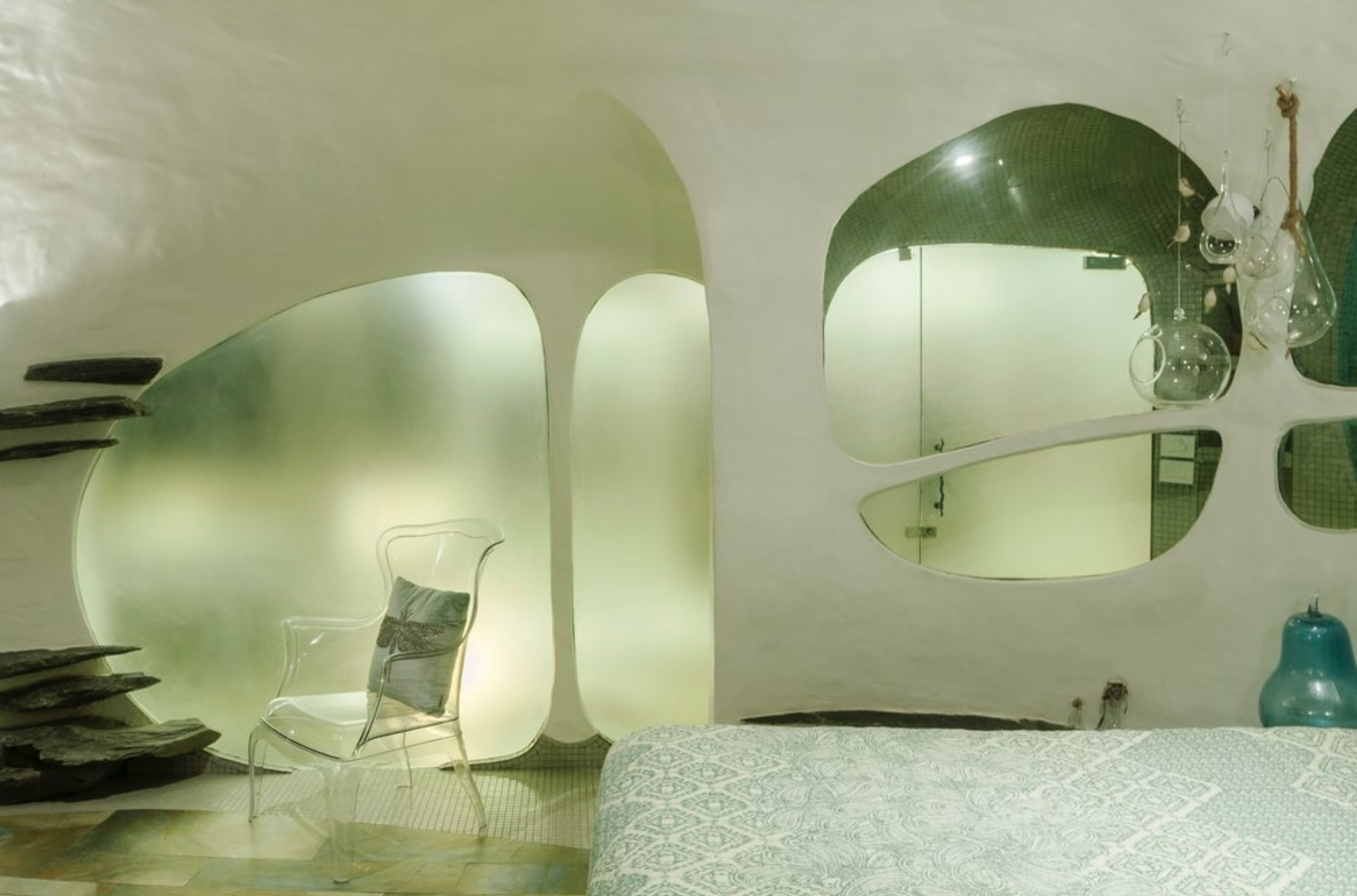 The Garden rooms, main bedroom with organic shaped white plaster walls, there is windows leading into the bathroom.