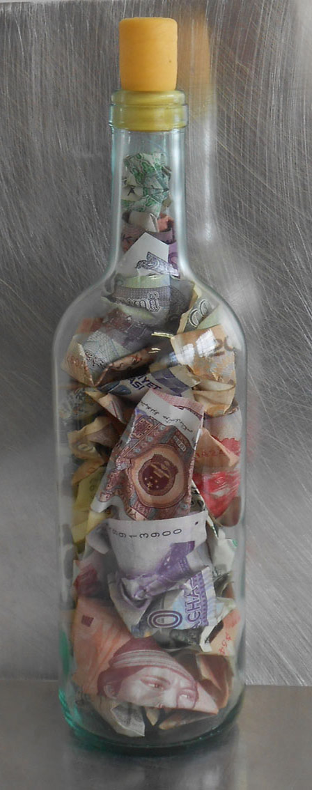 La bouteille est pleine, 2013. 23 x 10 cm. Monnaie dans un bouteille à la mer.