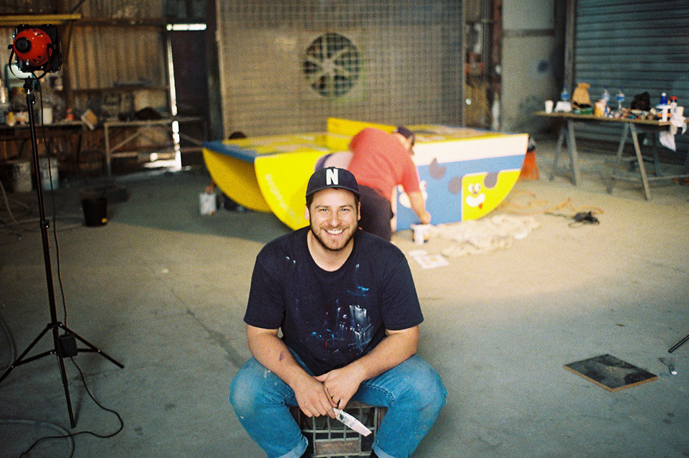 Artist Tim Meakins in front of a POPP HERO table being painted for the 2016 Olympic Games in Rio