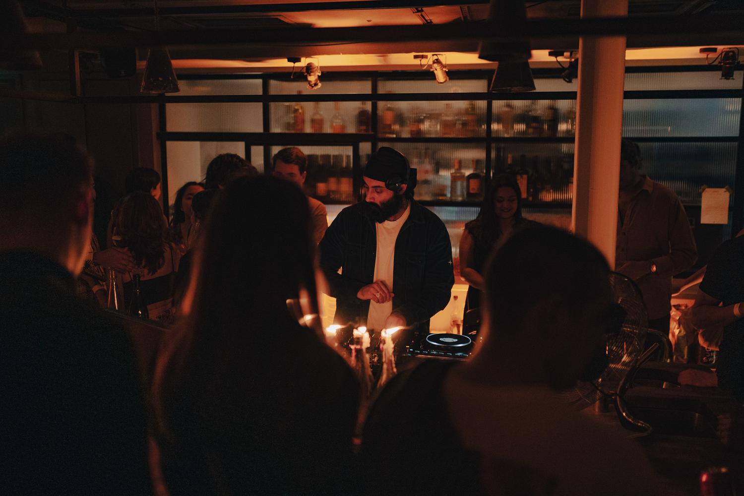 DJ performing for an intimate dinner crowd surrounded by candlelight during a Paired night at Carousel London.