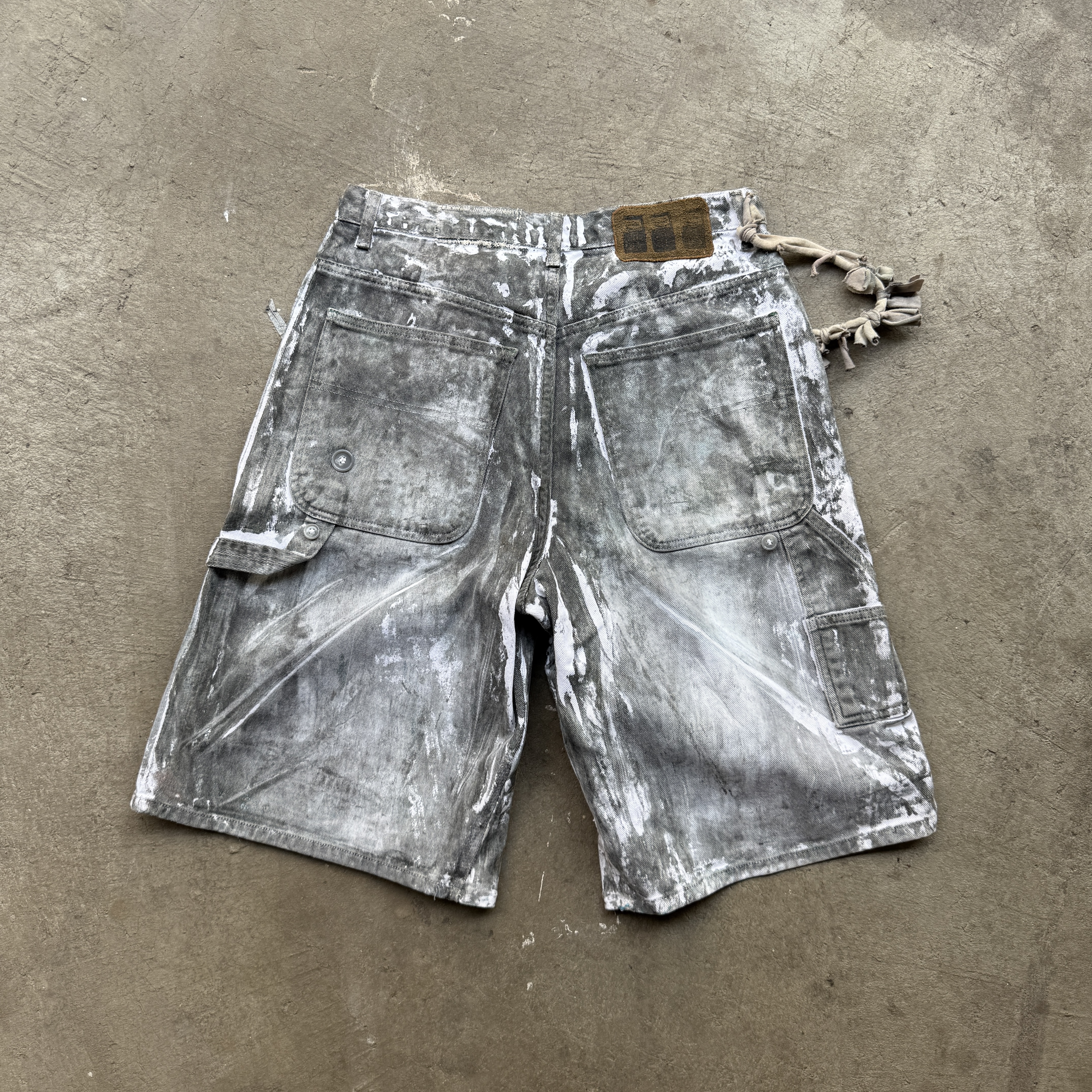 Reclaimed vintage surplus denim allover printed with copper, aluminum, iron & textile dye. Tailored to give a straight/wide fit. Fitted with dyed scrap chain, leather patches, and custom buttons
