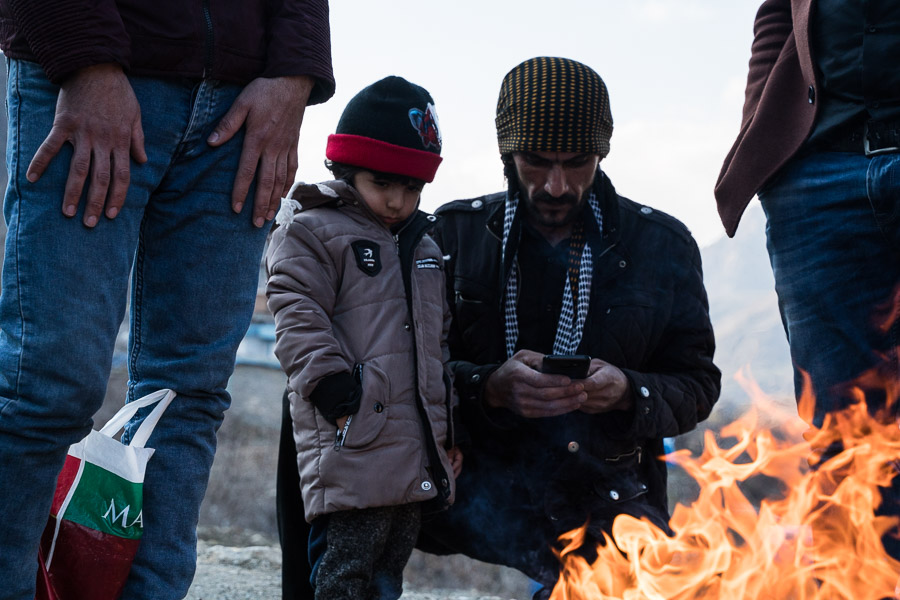 A gauche et &agrave; droite, deux hommes attendent pour retourner en Iran en passant la fronti&egrave;re &agrave; peids, apr&egrave;s une saison de travail en Irak.