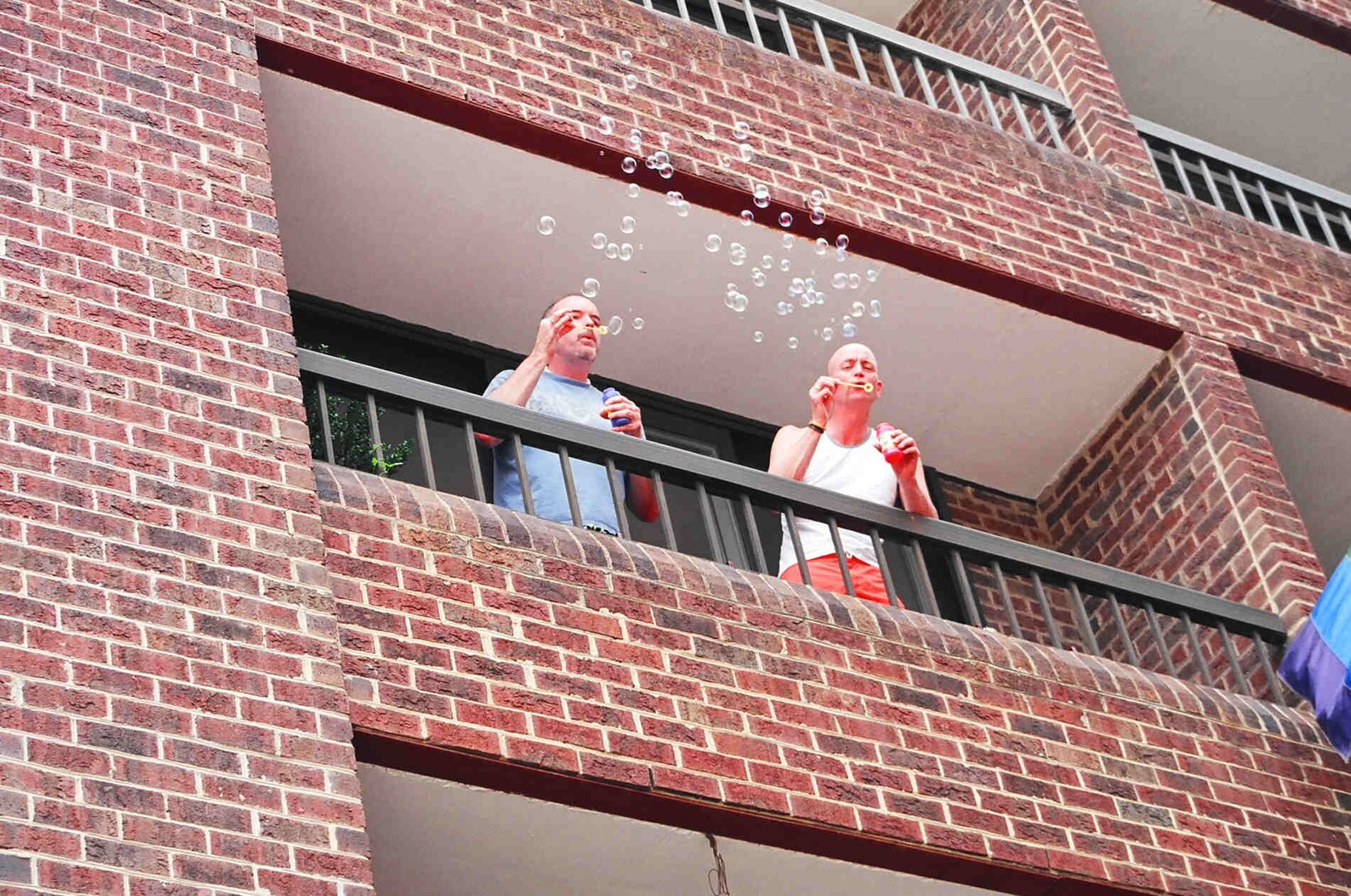 Voyeurs blowing bubbles from the balcony in anticipation of the Dyke March . On 17th Street just north of R . NW WDC . WDC . Saturday, 11 June 2005 Elvert Barnes Washington DC GAY PRIDE docu-project at elvertbarnes.com/DCGayPride