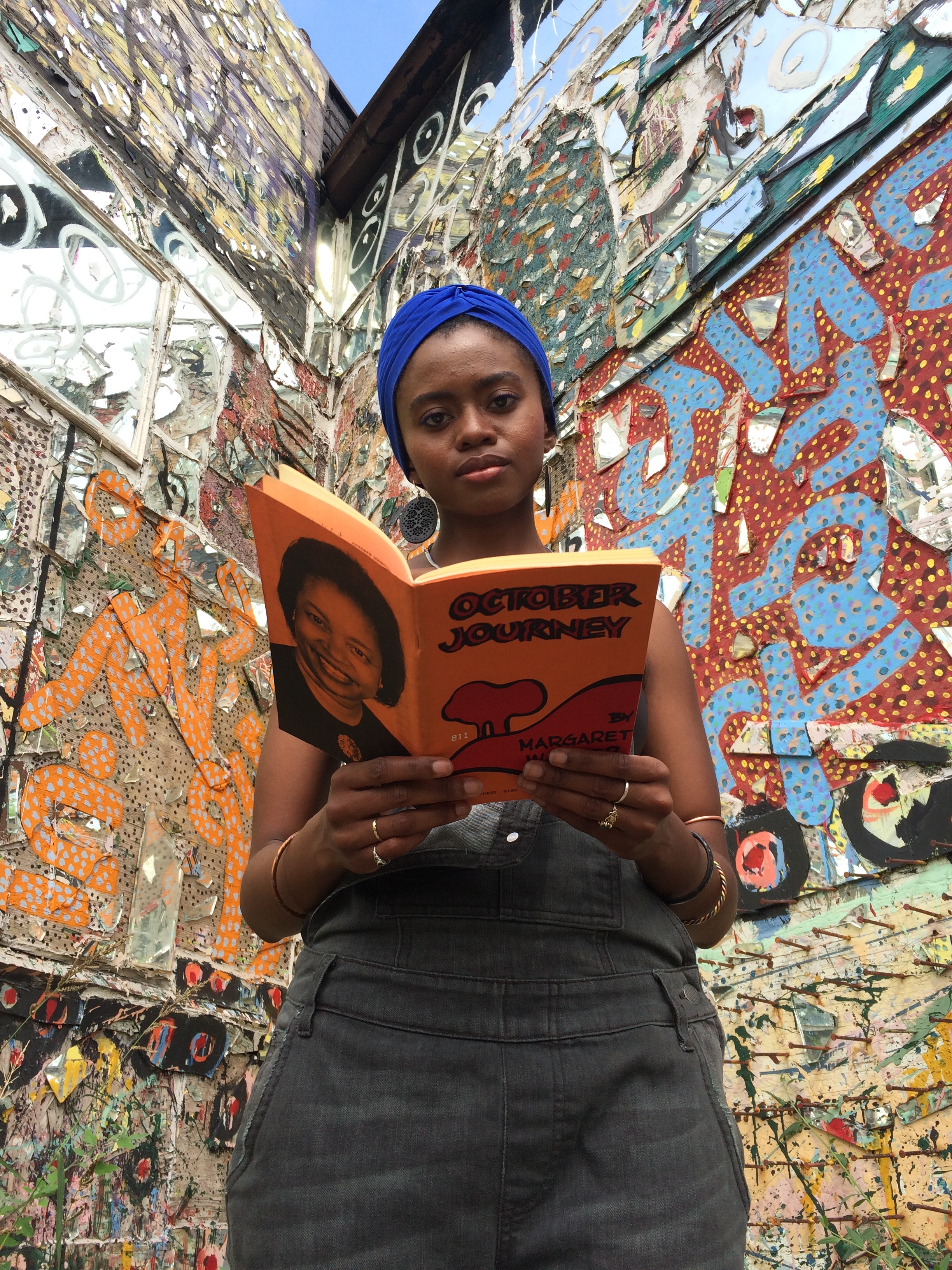 Jonni Page reads in front of the African Language Wall Dabls Mbad Bead Museum, Detroit, 2016 Fluid Frontiers production still Photo by Oona Mosna