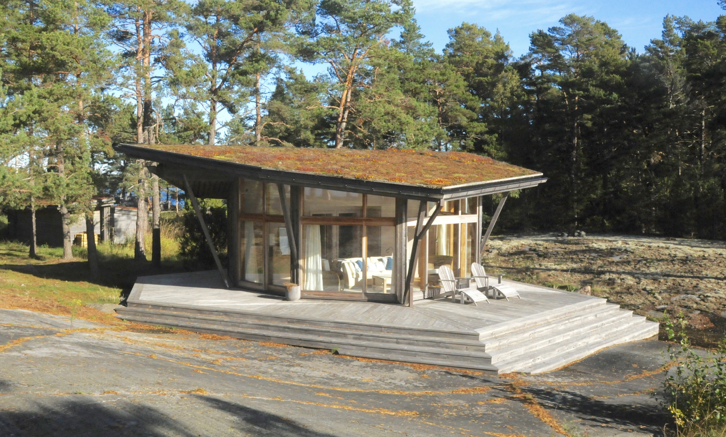 För att inte behöva skada de vackra, släta berghällarna har gäststugan “serverats” på en bricka, dvs en uppbyggd terrass runt huset i golvnivå som samtidigt ger fina uteplatser och en mjuk anpassning mot naturen
