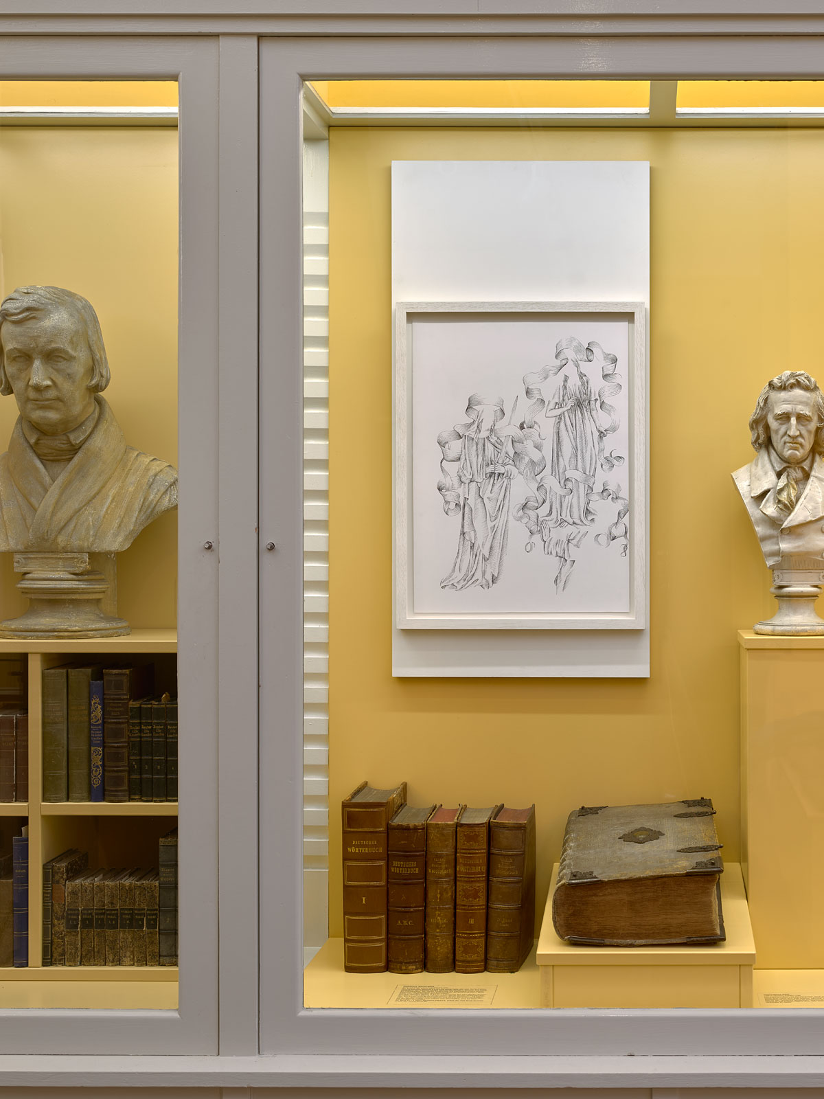 Sybillas flanked by busts of Wilhelm and Jakob Grimm, below: their personal copy of The German Dictionary