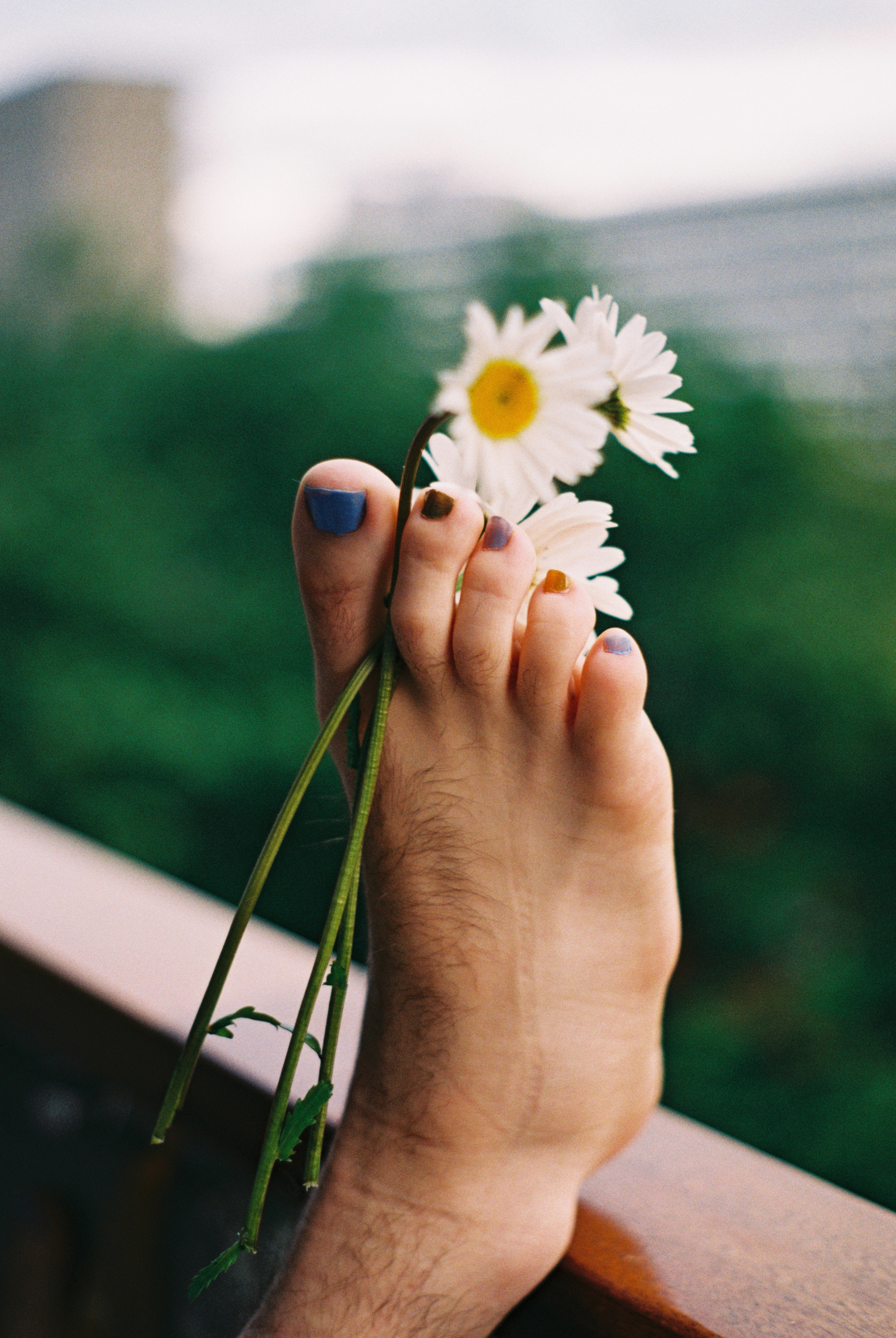 Man's foot with painted toenails and flowers