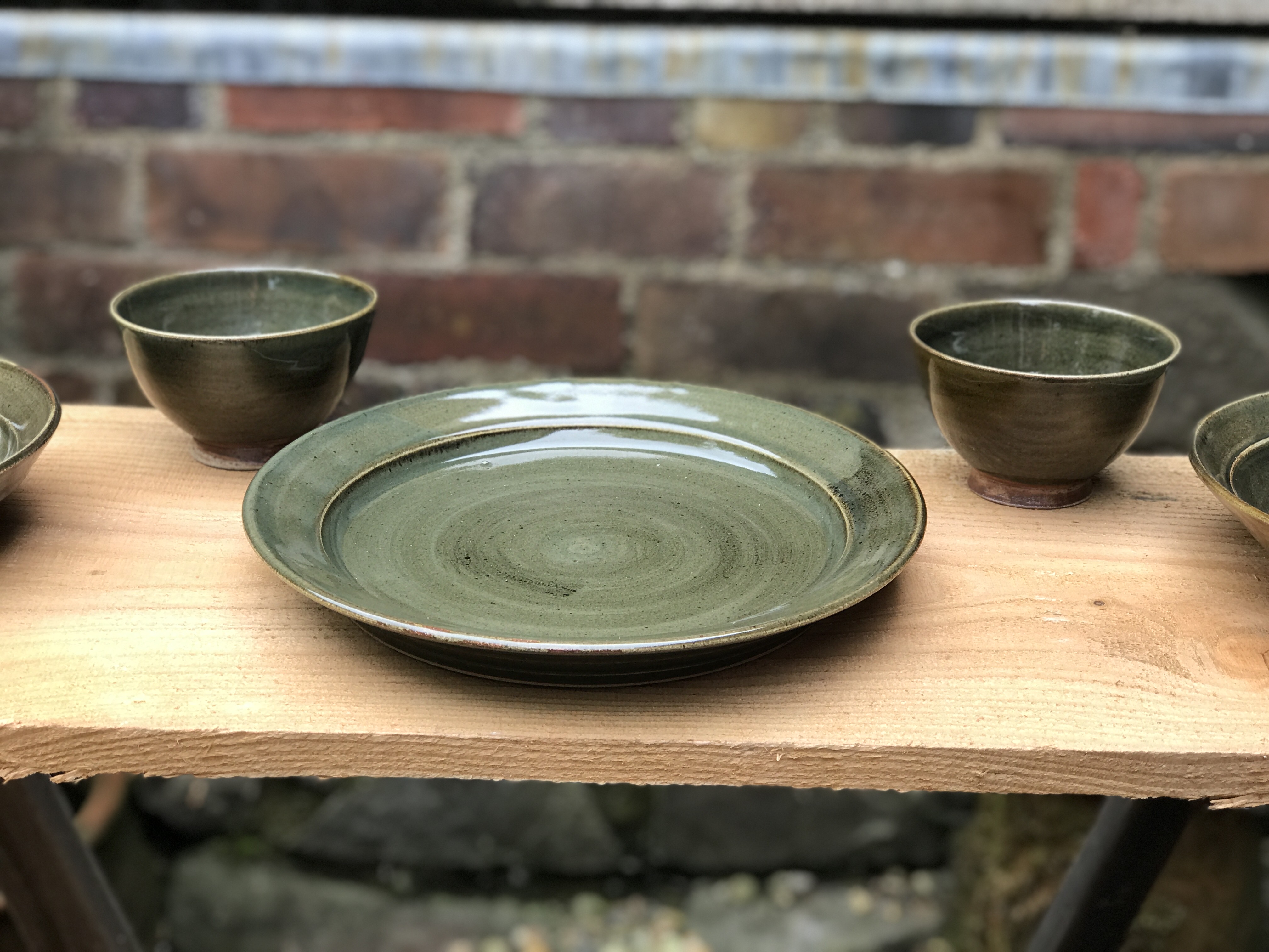 Table service in dark celadon with ochre wash.