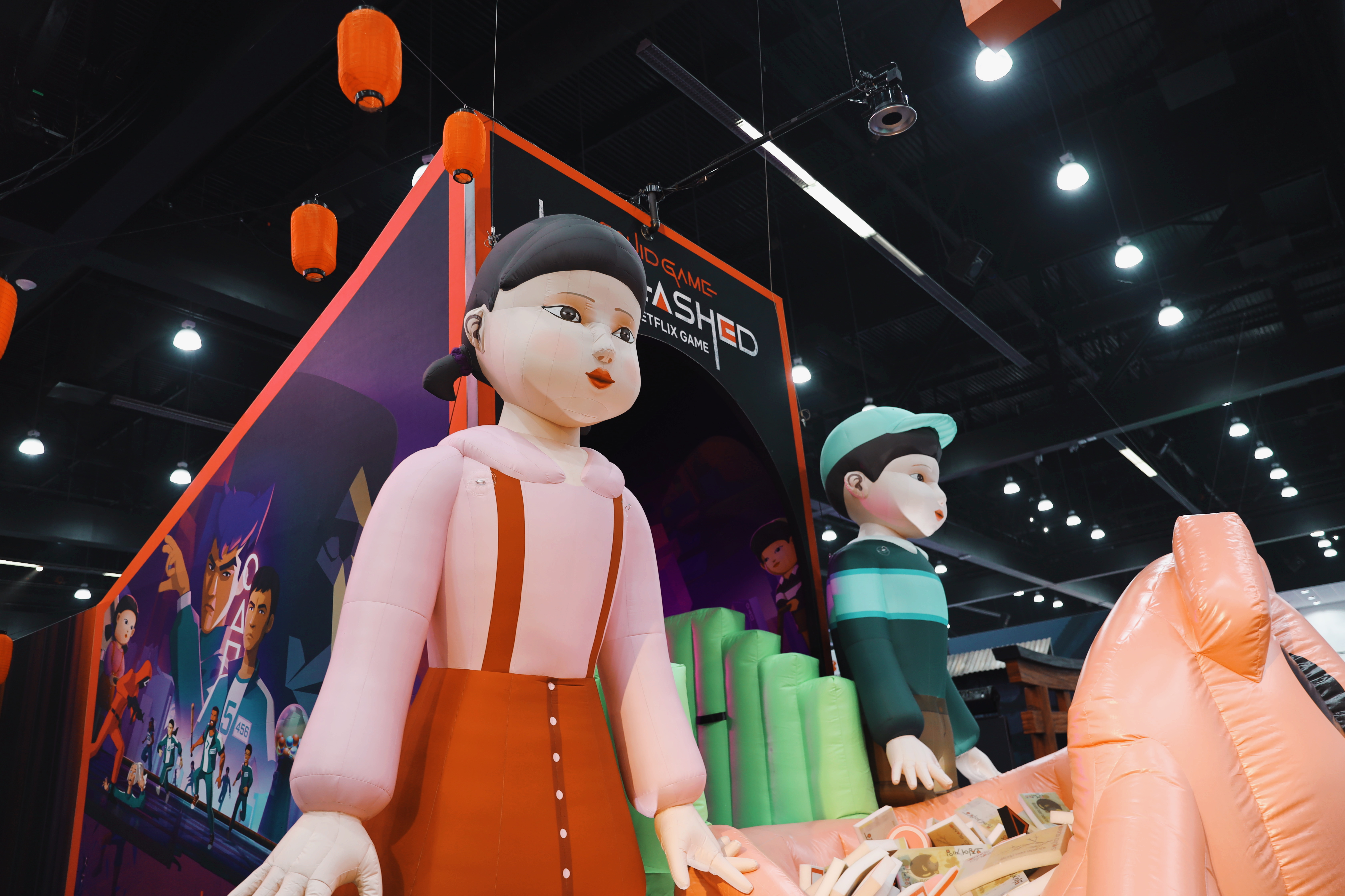 FOURTH SECTION: Squid Game dolls watch over the piggy bank money pit.