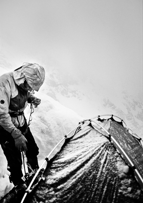 Boris Avdeev getting harness and climbing gear ready for another day of climbing on the south pillar (5B) of Shkhara (5193m, Caucasus).