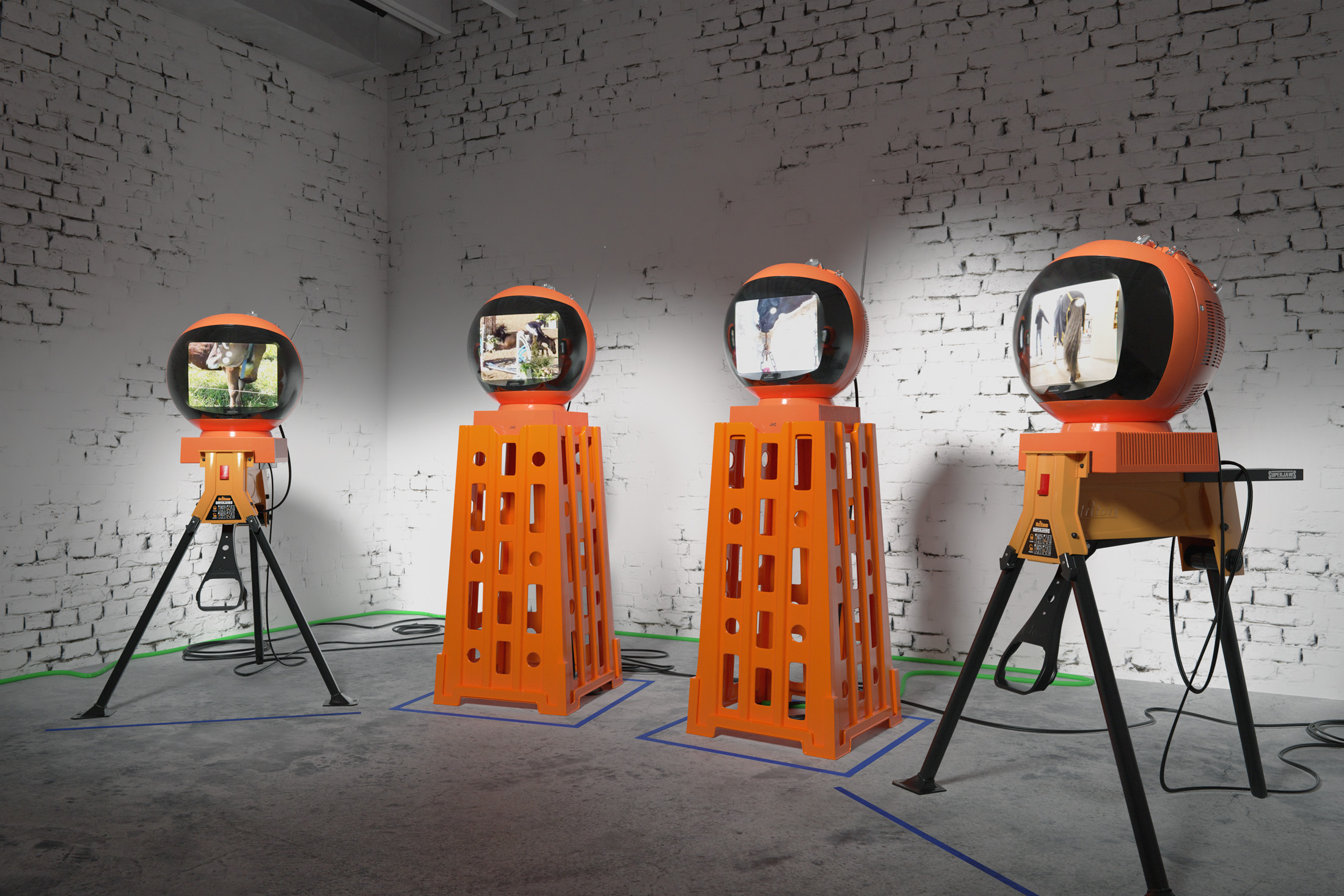 Echoes in an empty cage, 2023, refurbished videospheres, superjaw sawhorses, standtalls, media players, cables, tape, dimensions variable