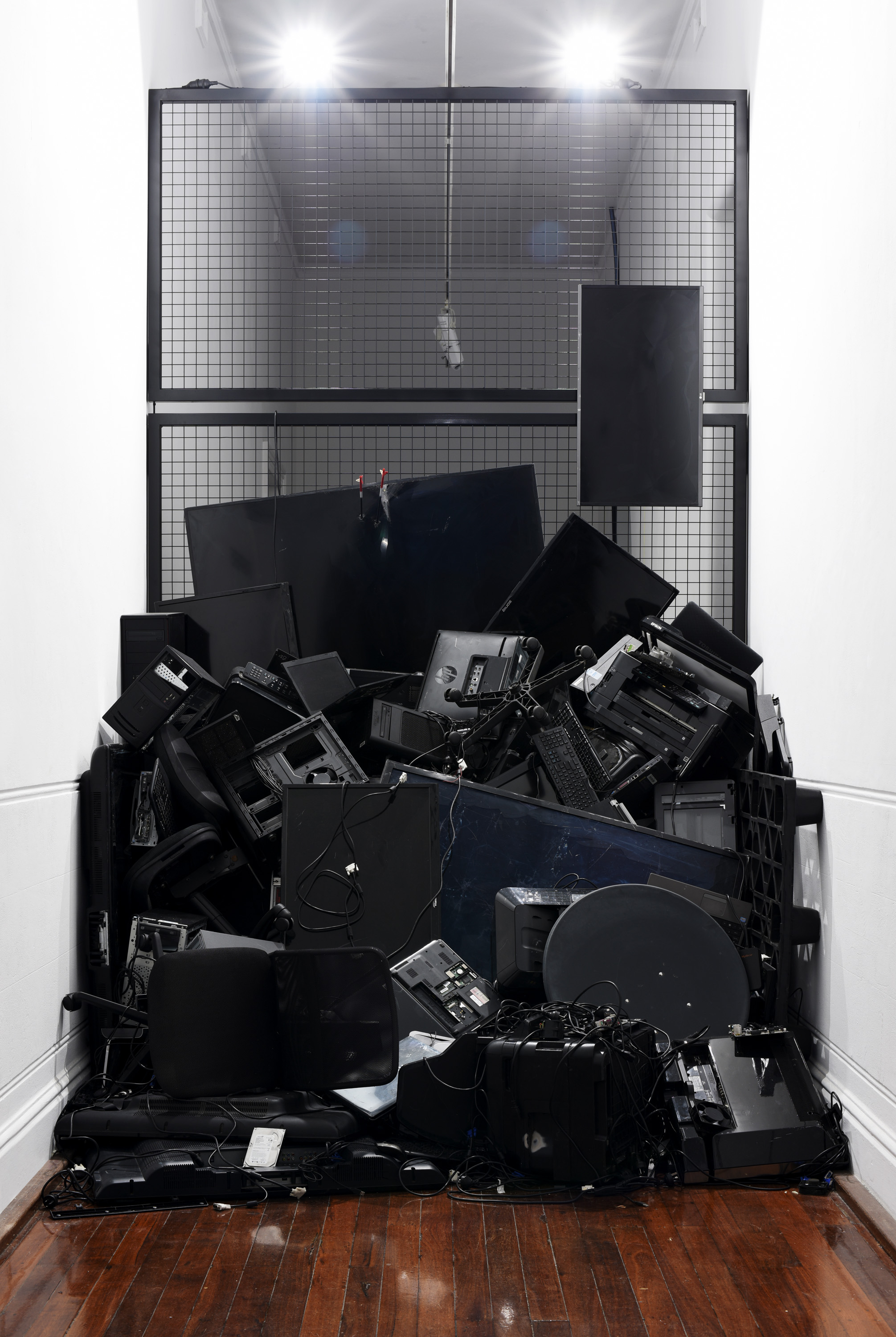 Dan McCabe, Guy Louden and Loren Kronemyer, E-Waste Barricade, 2019, Industrial enamel, steel, LED flood lights, arrows and ewaste, 425cm x 240cm x 300cm