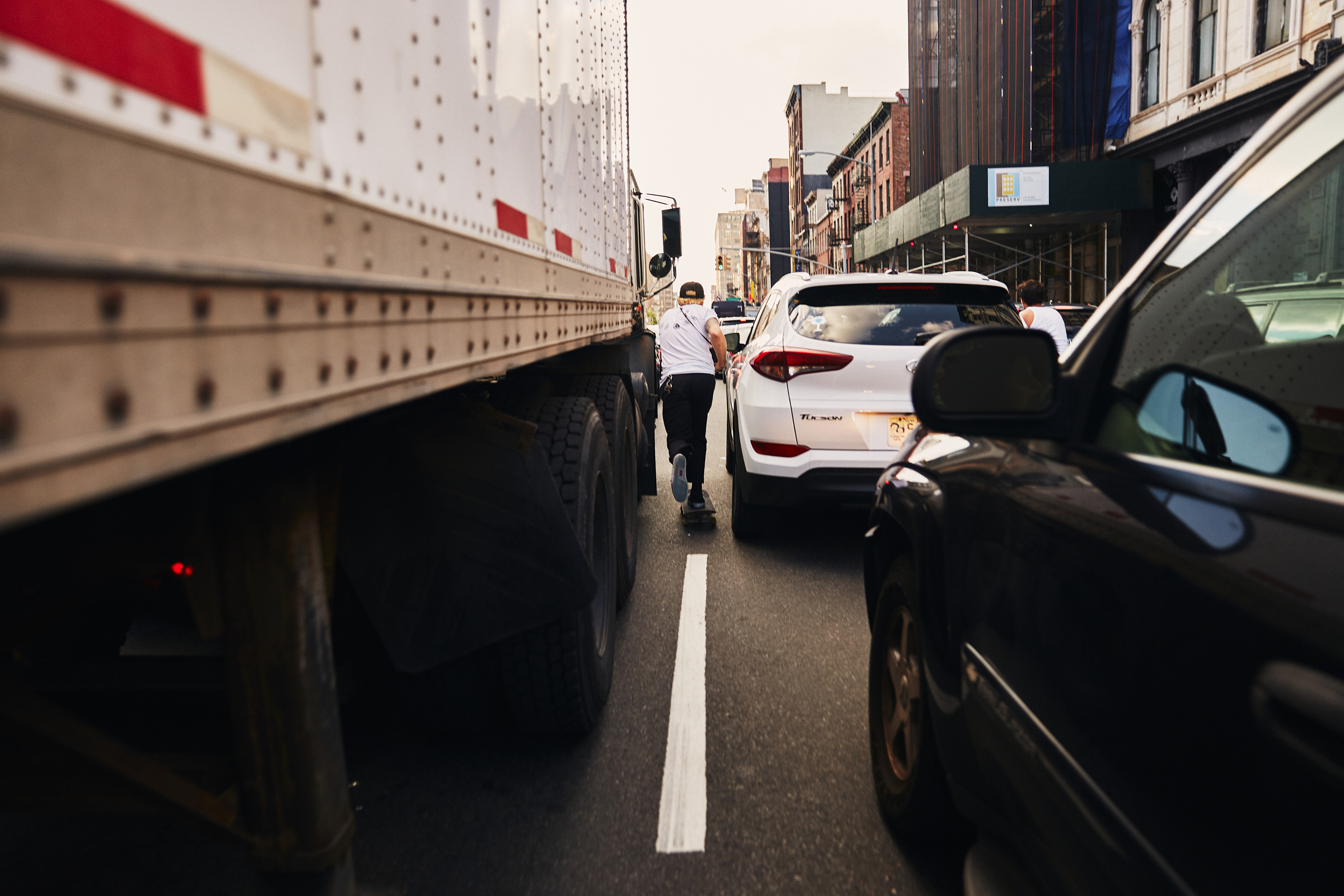 Skateboarder skating through New York city traffic photographed by Dublin based lifestyle, fashion, and advertising photographer Alex Sheridan 