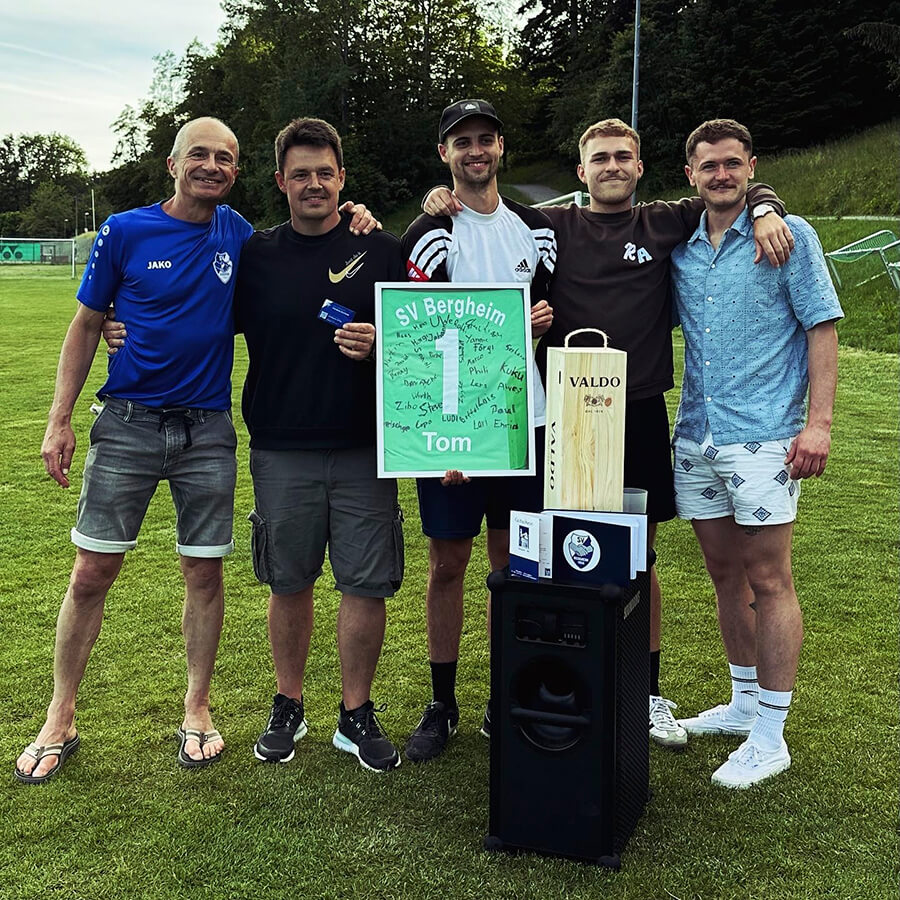 People with presents are smiling for the camera after the retirement of the coach